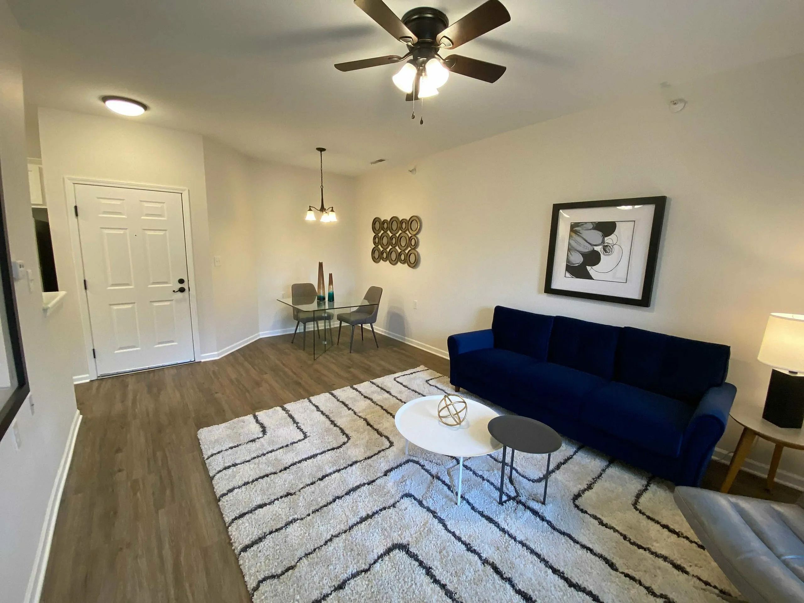 Modern living room with elegant blue sofa, stylish dining area, and chic decor, perfect for a cozy and inviting home.