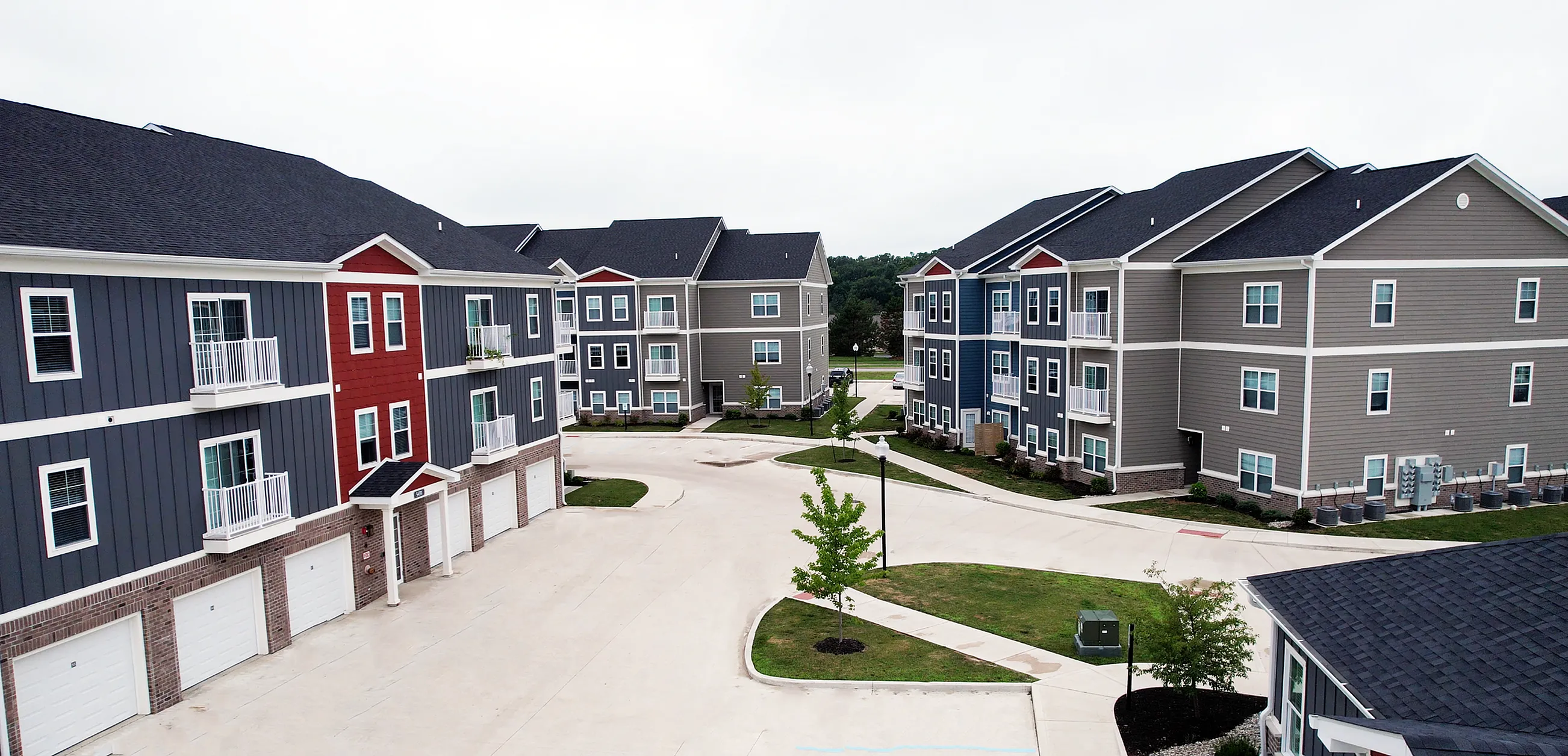 Charming apartment complex with colorful facades, lush green spaces, and modern balconies offering a serene living environment.