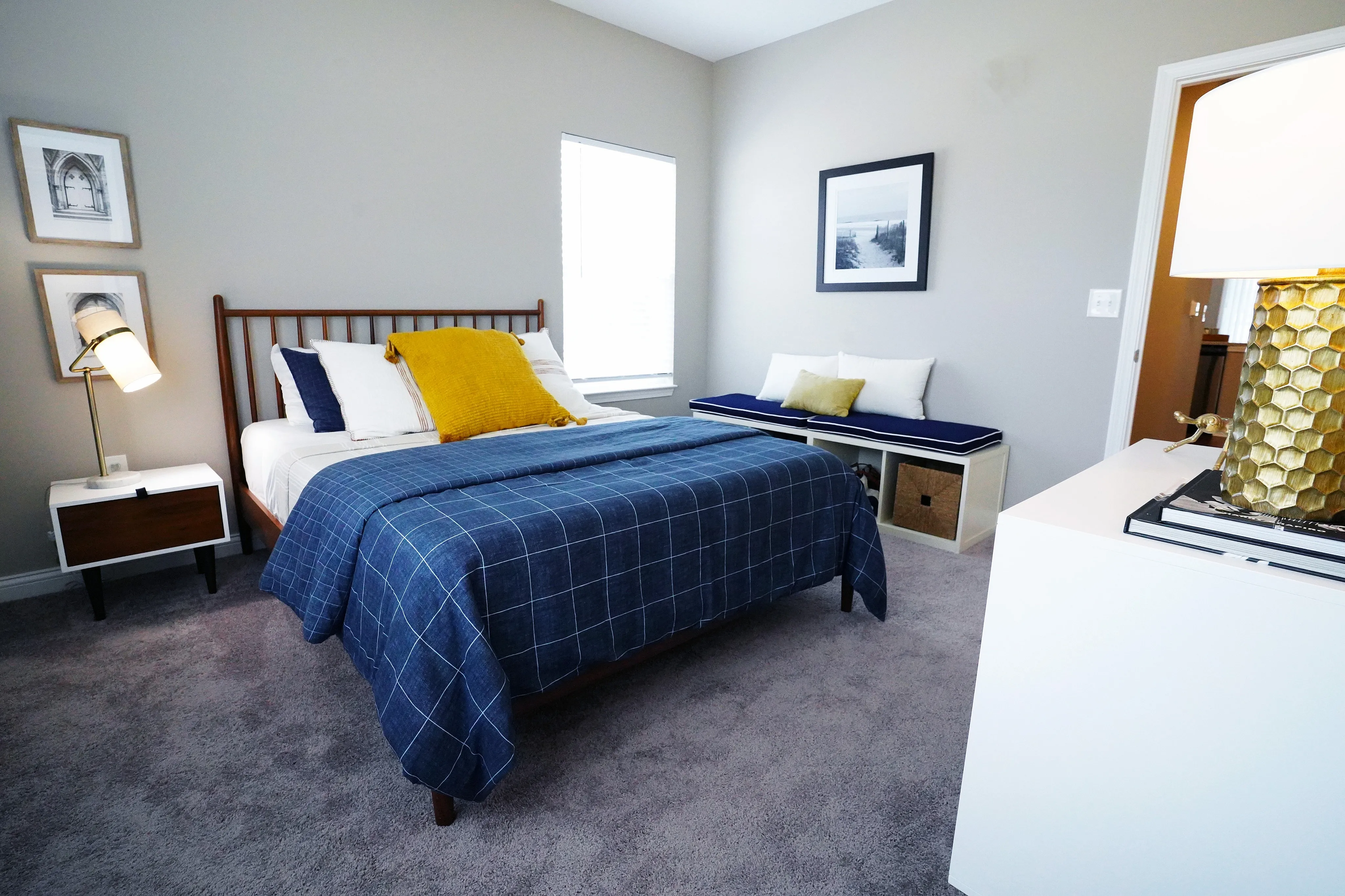 Cozy bedroom with stylish decor featuring a comfortable bed, elegant bedside lamp, and inviting window seating.