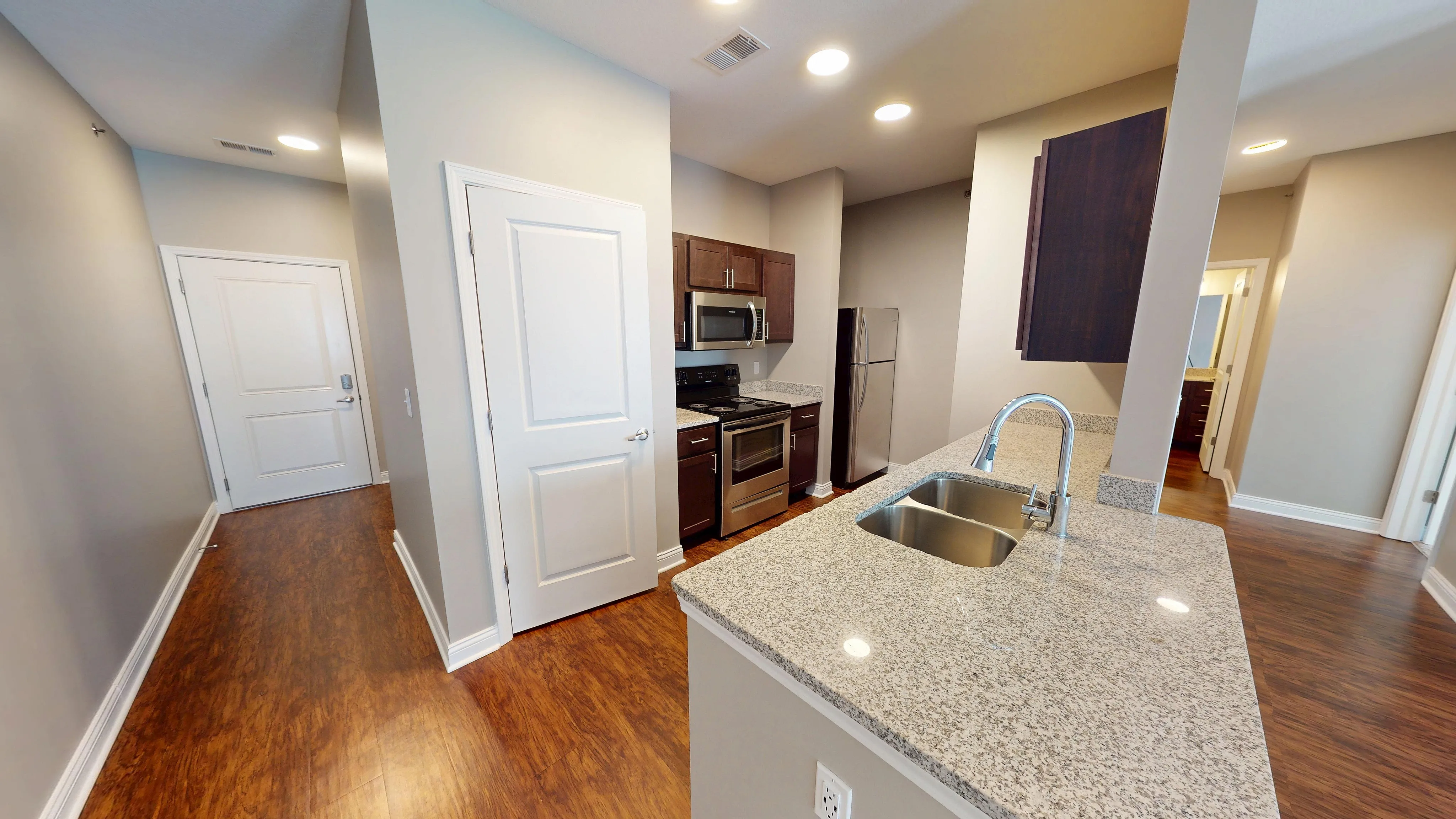 Contemporary kitchen with sleek granite countertops, stainless steel appliances, and inviting hardwood floors.
