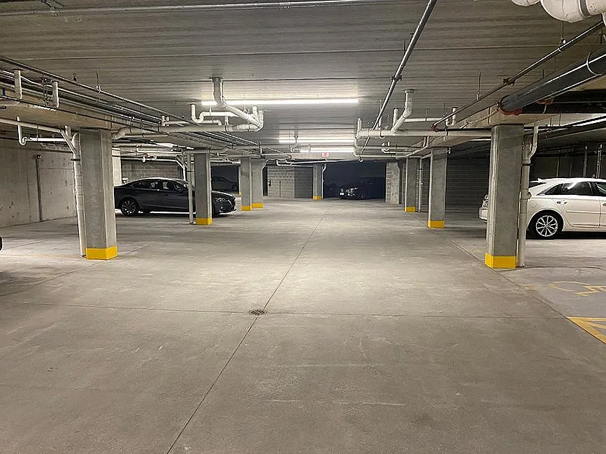 Spacious underground parking garage featuring well-lit spaces, secure environment, and convenient access for residents.
