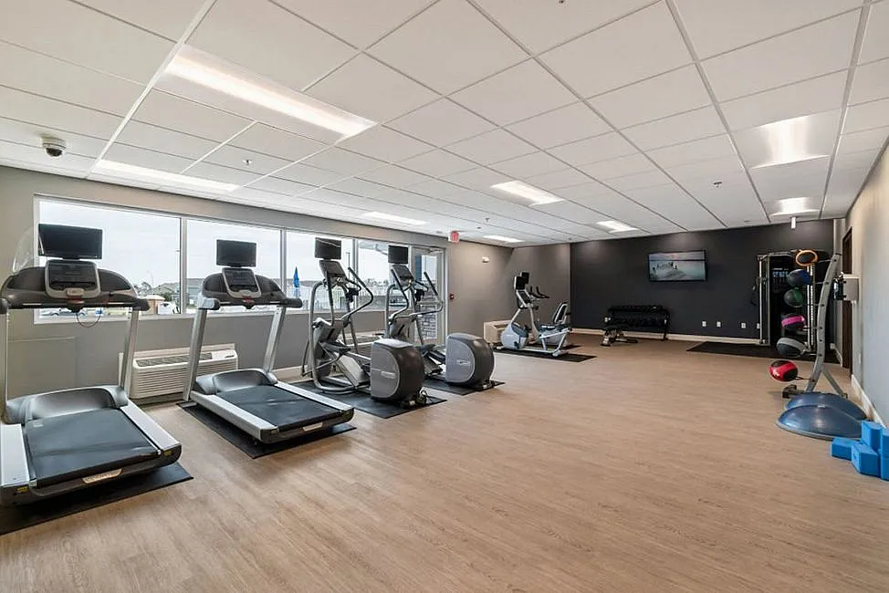 Modern fitness center with treadmills, exercise bikes, and vibrant natural lighting, perfect for energizing workouts.