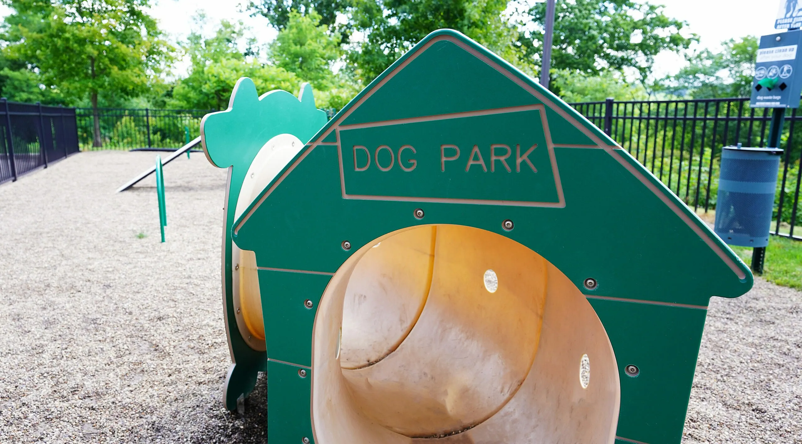 Charming dog park with playful structures and lush greenery, perfect for pet-friendly apartments.