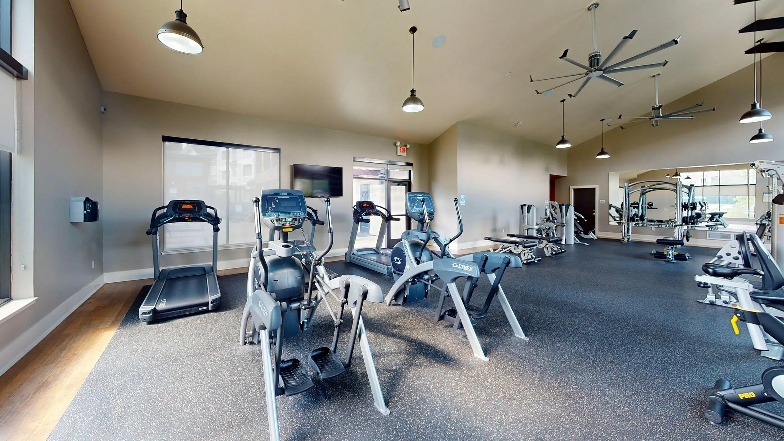 Modern fitness center with state-of-the-art equipment, bright natural light, and spacious workout area.