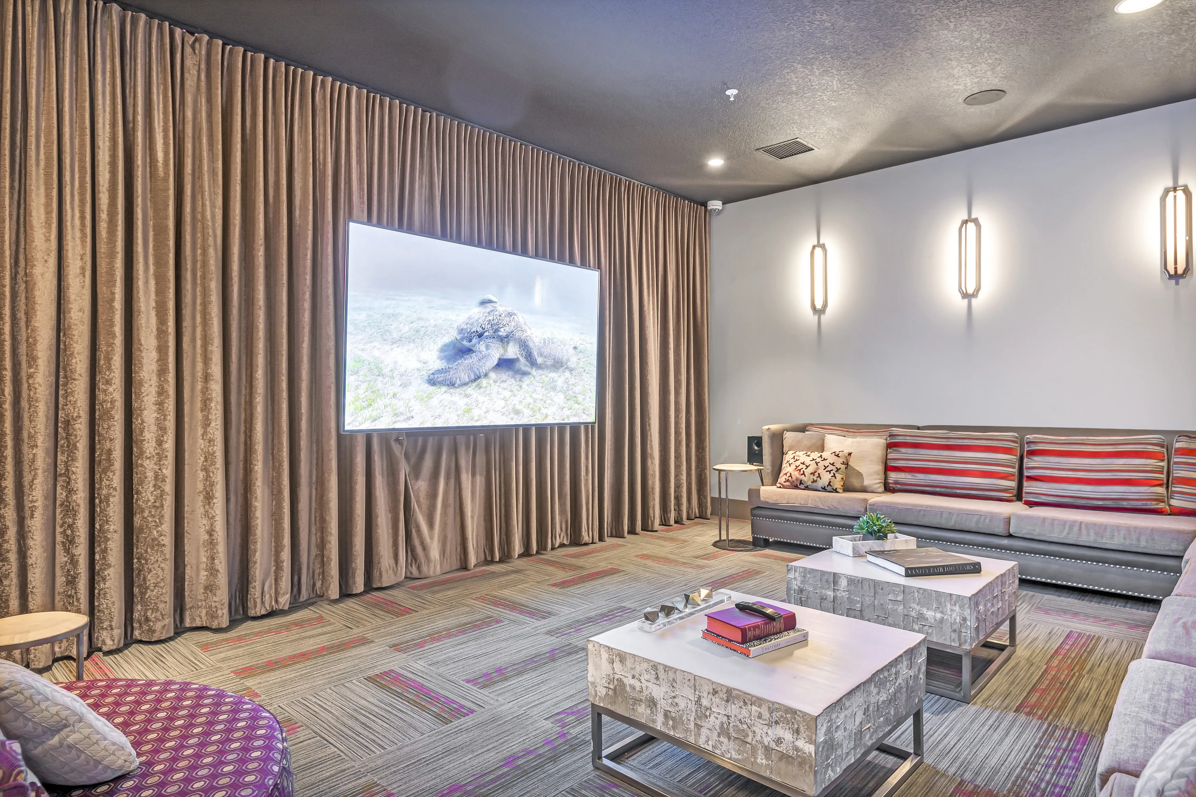 Chic and cozy media room with plush seating, modern decor, and wall-mounted television for immersive entertainment.