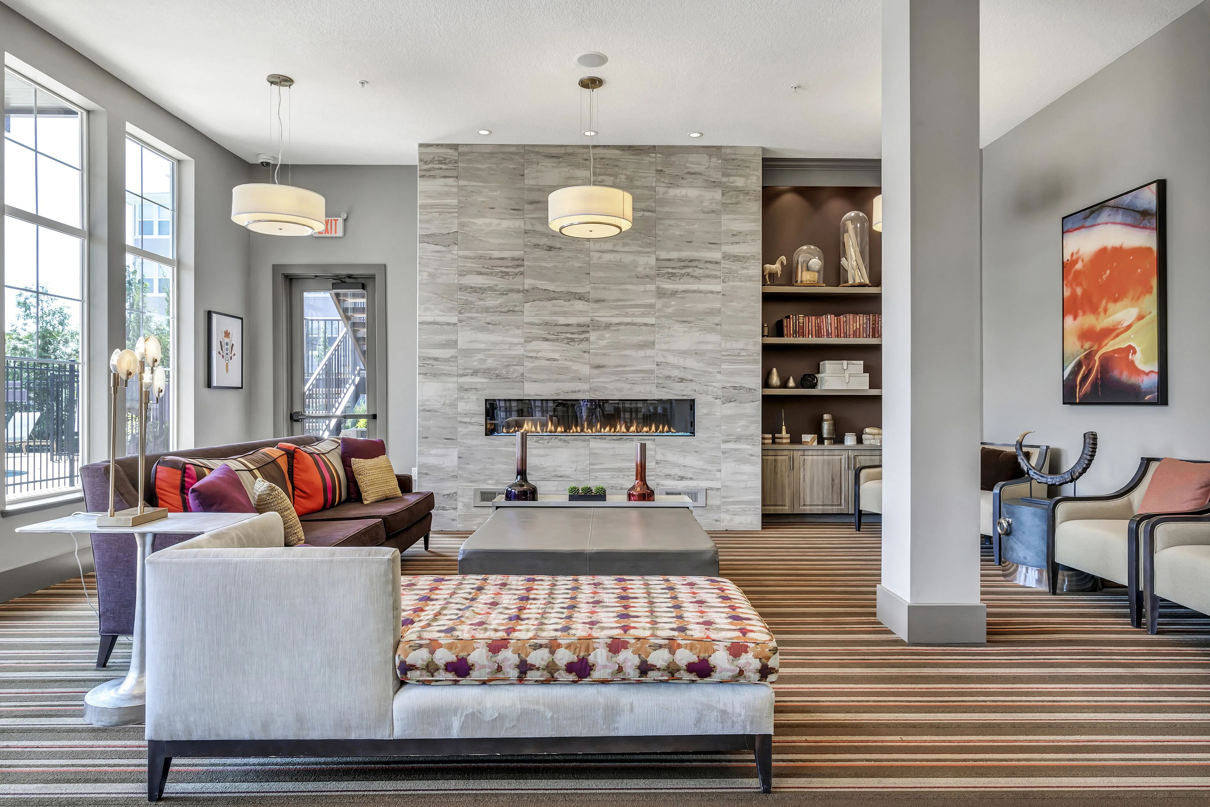 Elegant living room with modern decor, featuring a sleek fireplace, cozy seating area, and large windows allowing natural light to flood in.