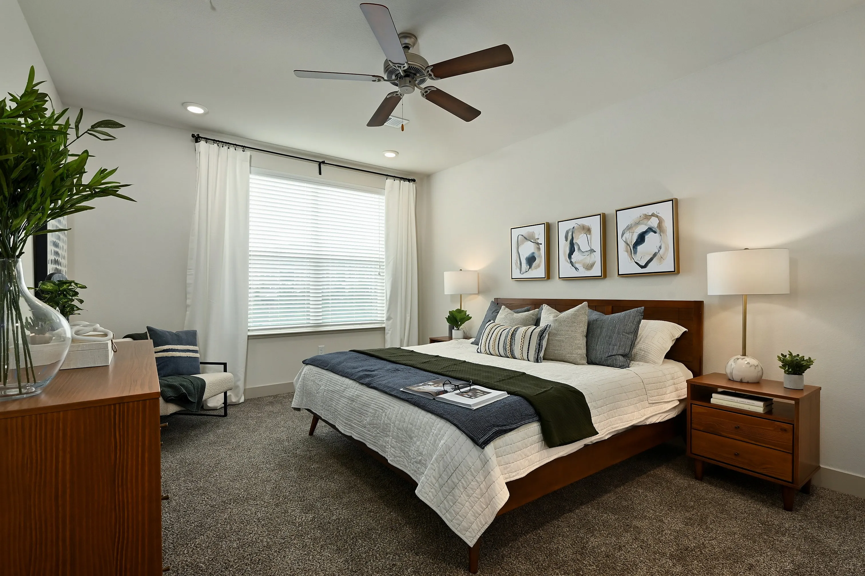 Inviting bedroom with a modern design, featuring a cozy bed with stylish cushions, warm wooden furniture, elegant decor, and abundant natural light.