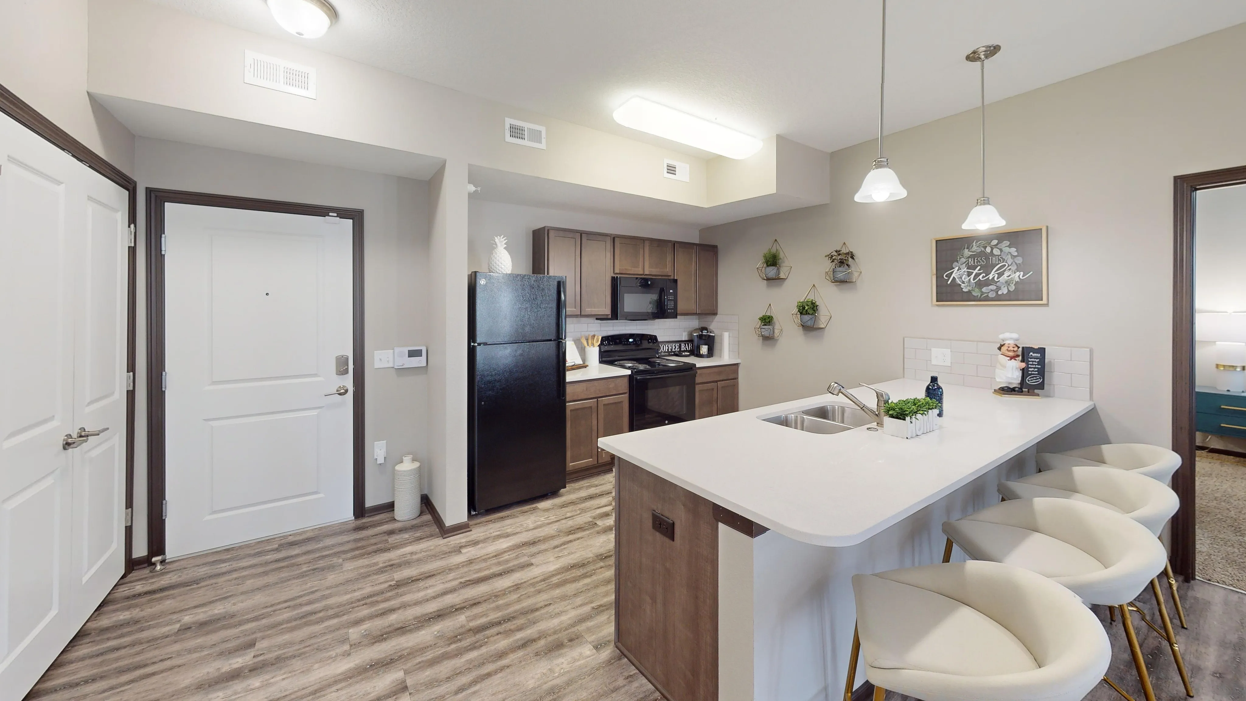 Chic and inviting kitchen featuring modern appliances, stylish bar stools, and elegant decor for a homely touch.