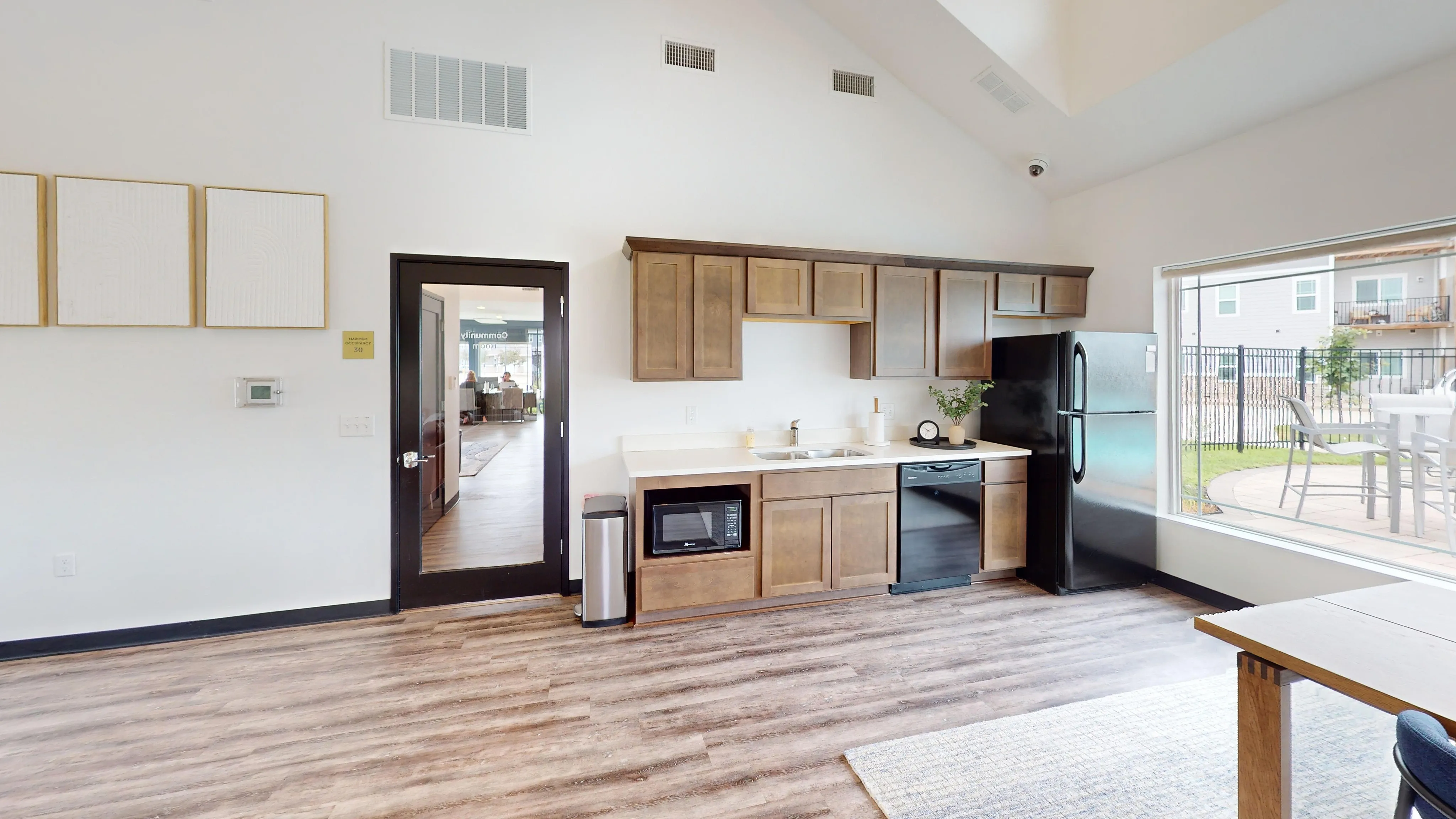Bright and airy modern kitchen with sleek wood cabinets, stainless steel appliances, and large windows offering plenty of natural light.