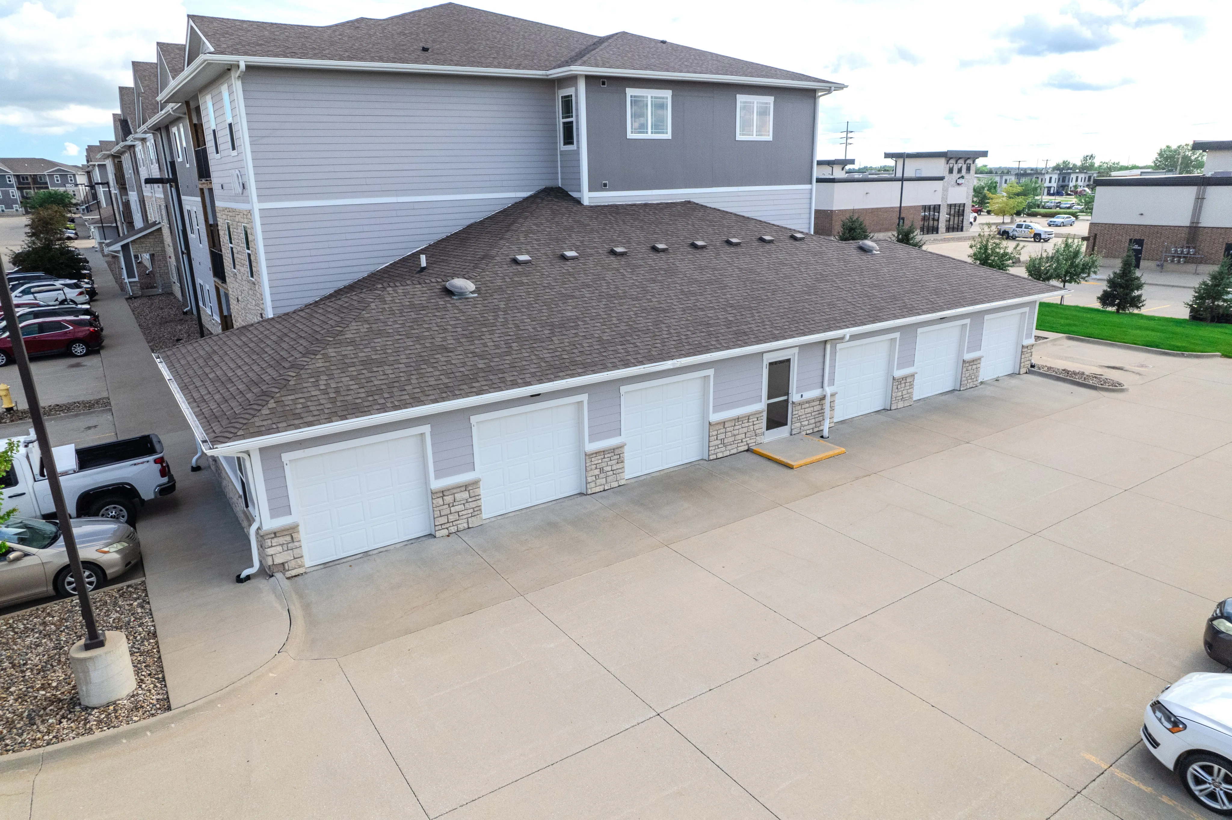Modern apartment complex featuring convenient attached garages and ample parking space, set in a well-maintained urban area.