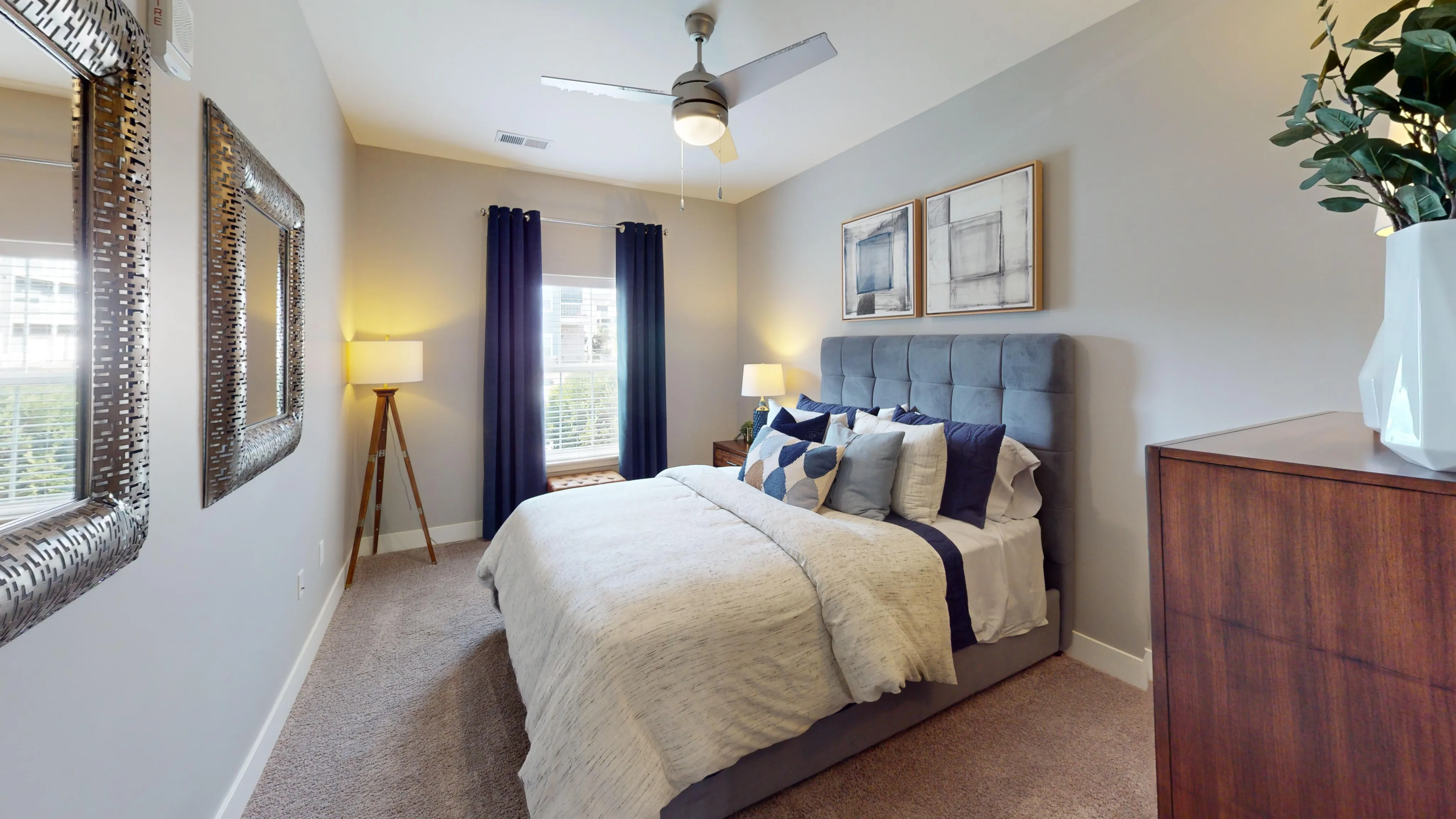 Elegant bedroom with plush bedding, stylish decor, and abundant natural light from a large window, creating a cozy and welcoming ambiance.