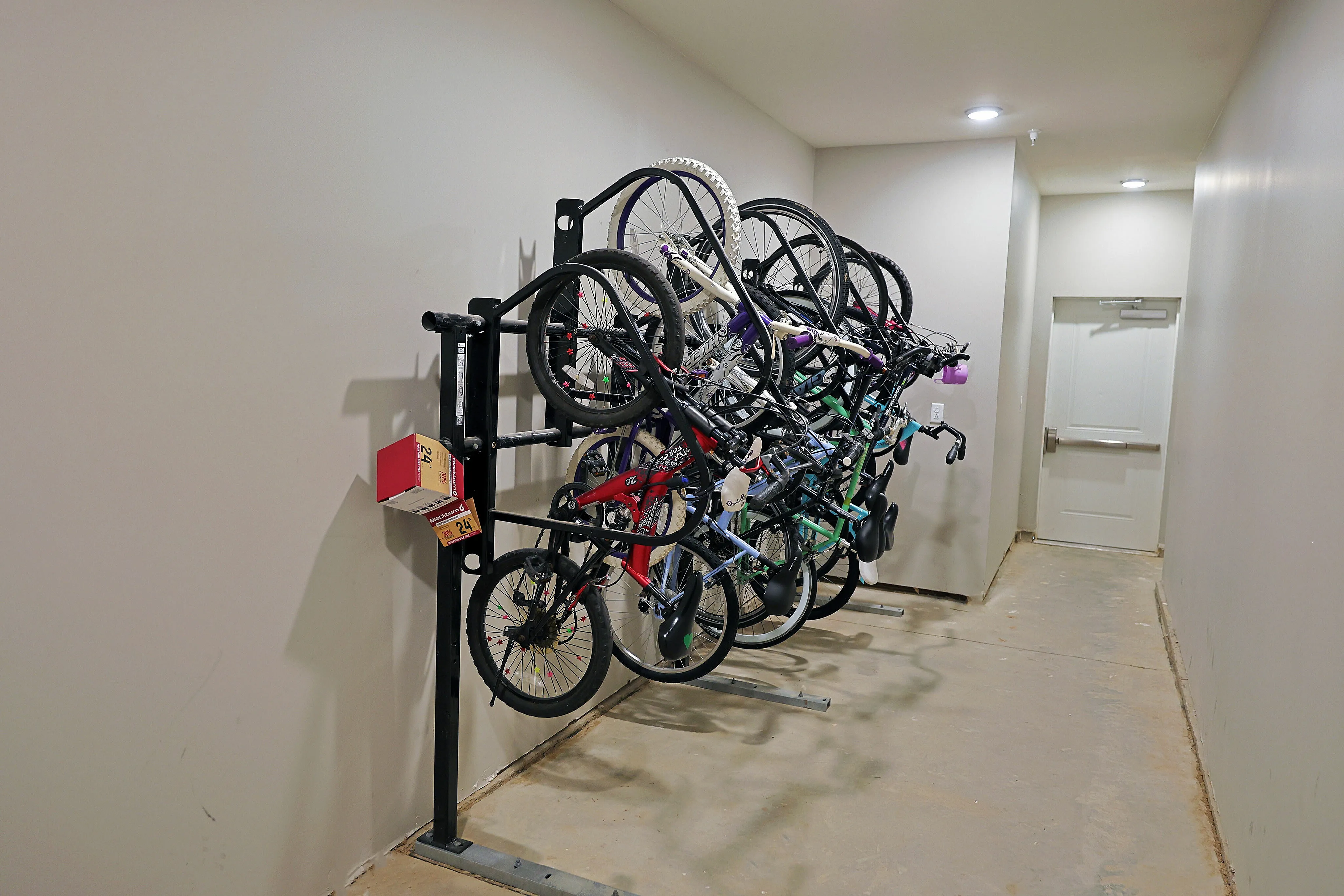 Secure and spacious bike storage area with multiple bicycles neatly hung on sturdy racks, offering convenience for active residents.