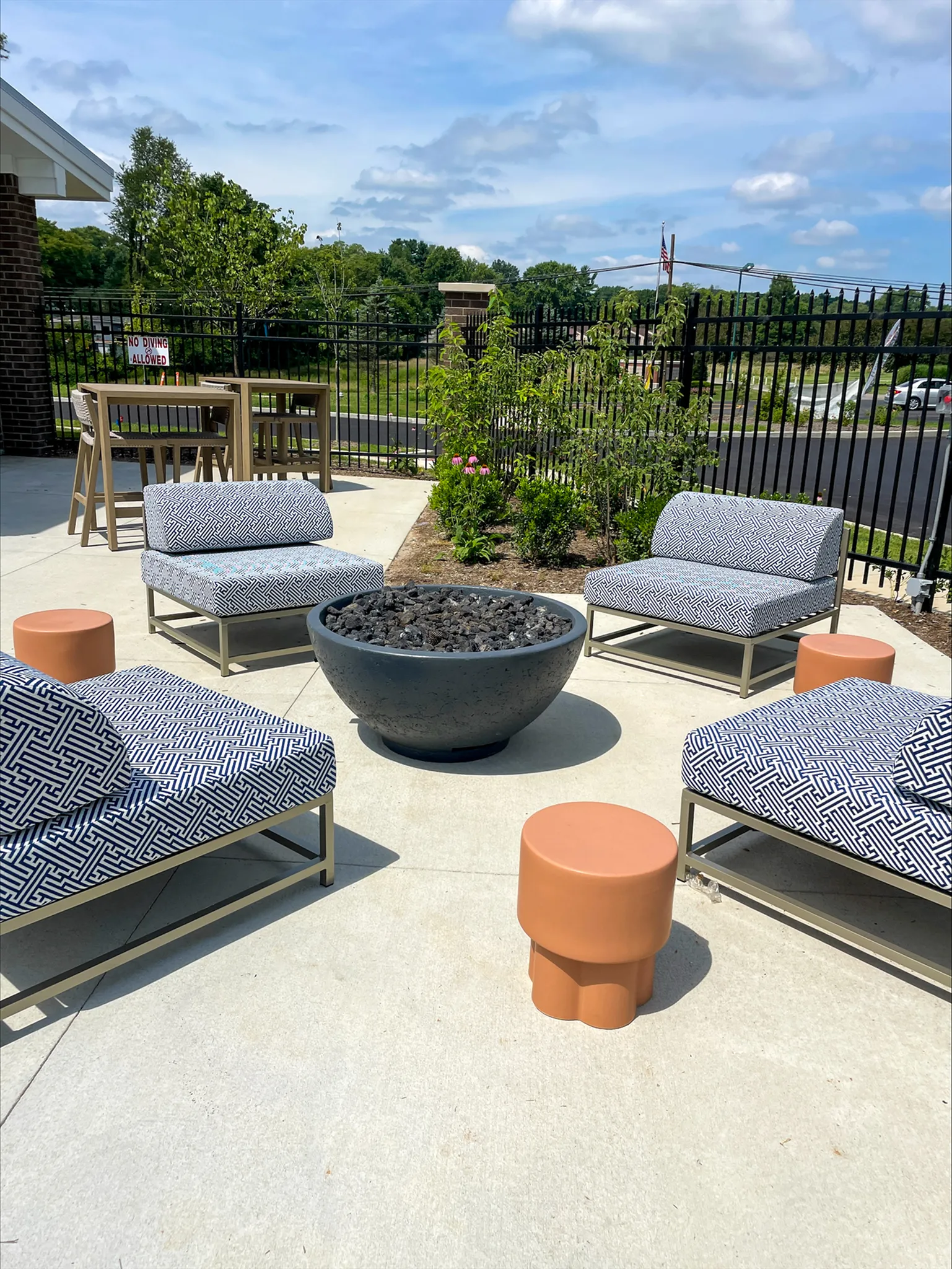 Inviting outdoor patio with modern seating around a cozy fire pit, perfect for relaxing under clear skies.