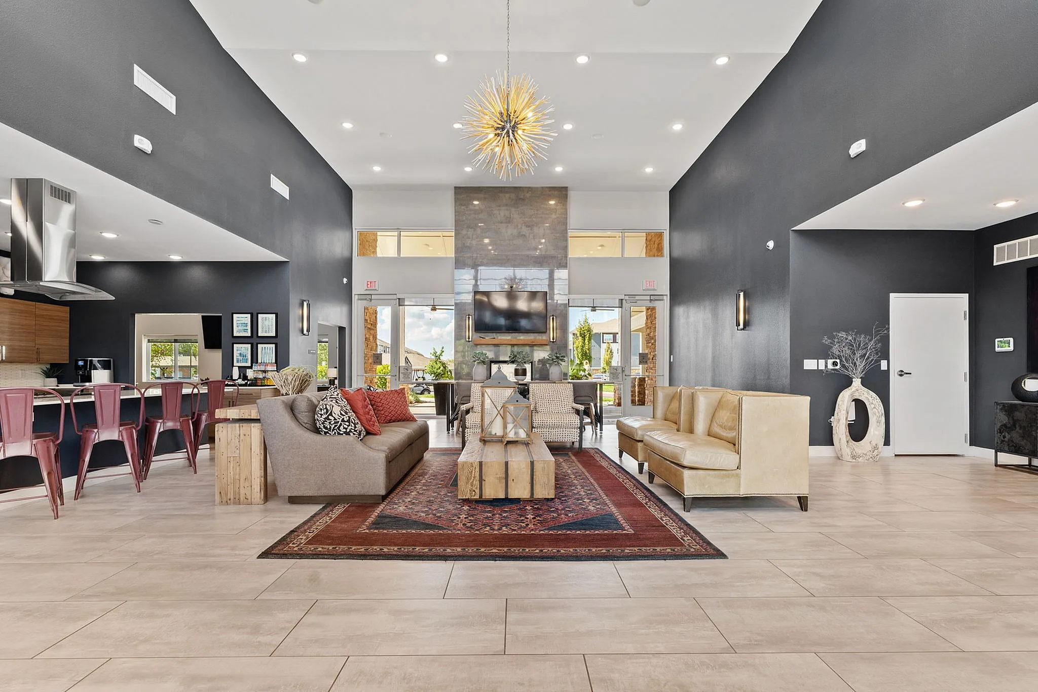 Luxurious open-concept living space with high ceilings, elegant seating, a modern chandelier, and vibrant decor.