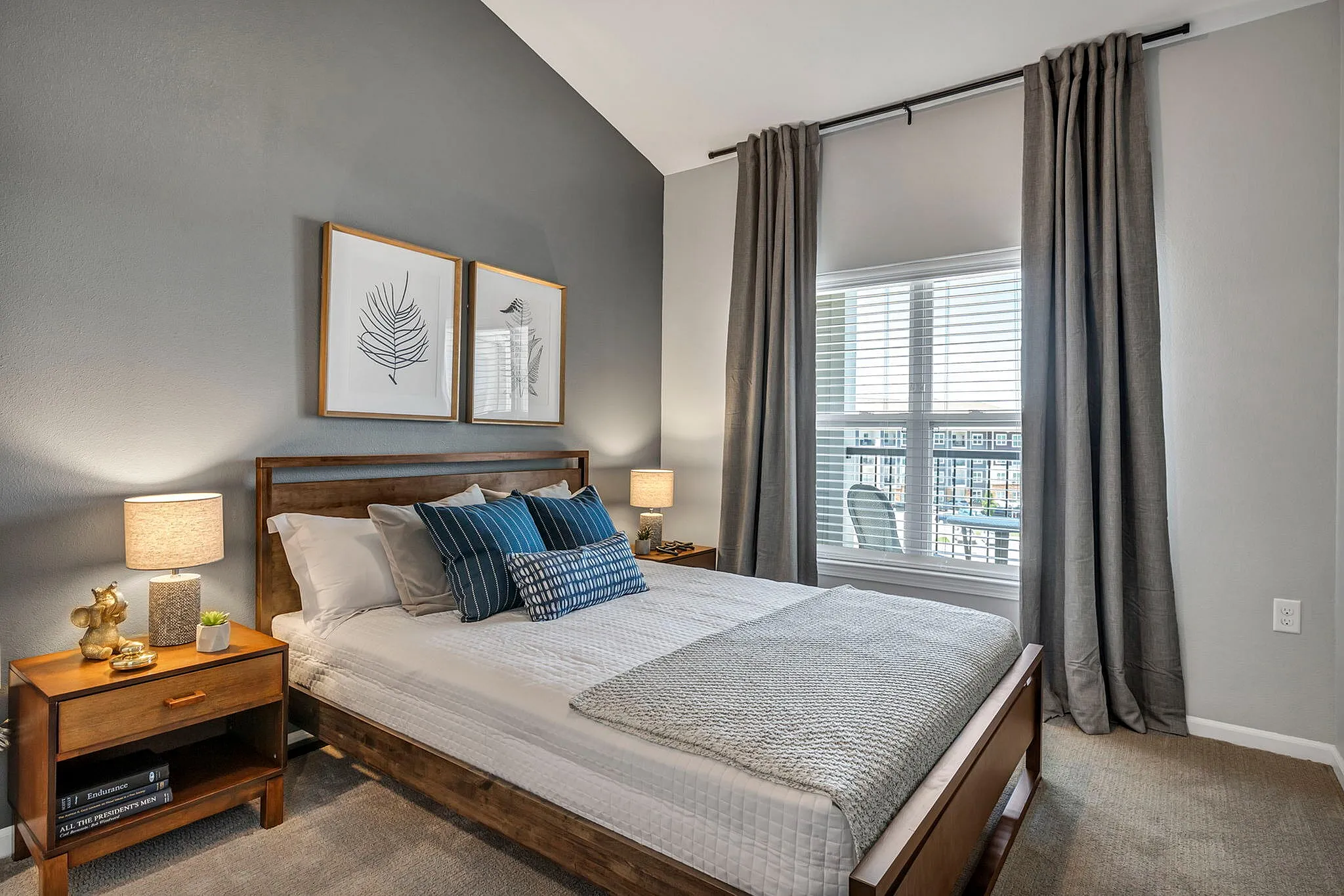 Elegant bedroom with a stylish modern design, featuring a cozy bed with plush pillows, warm lighting, and large window with chic curtains.