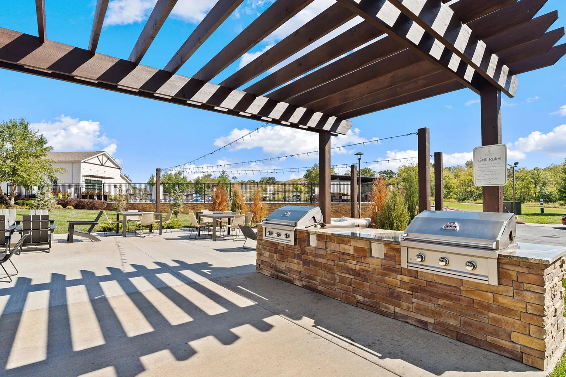 Charming outdoor patio with modern grill stations and shaded seating, perfect for entertaining and enjoying sunny days.