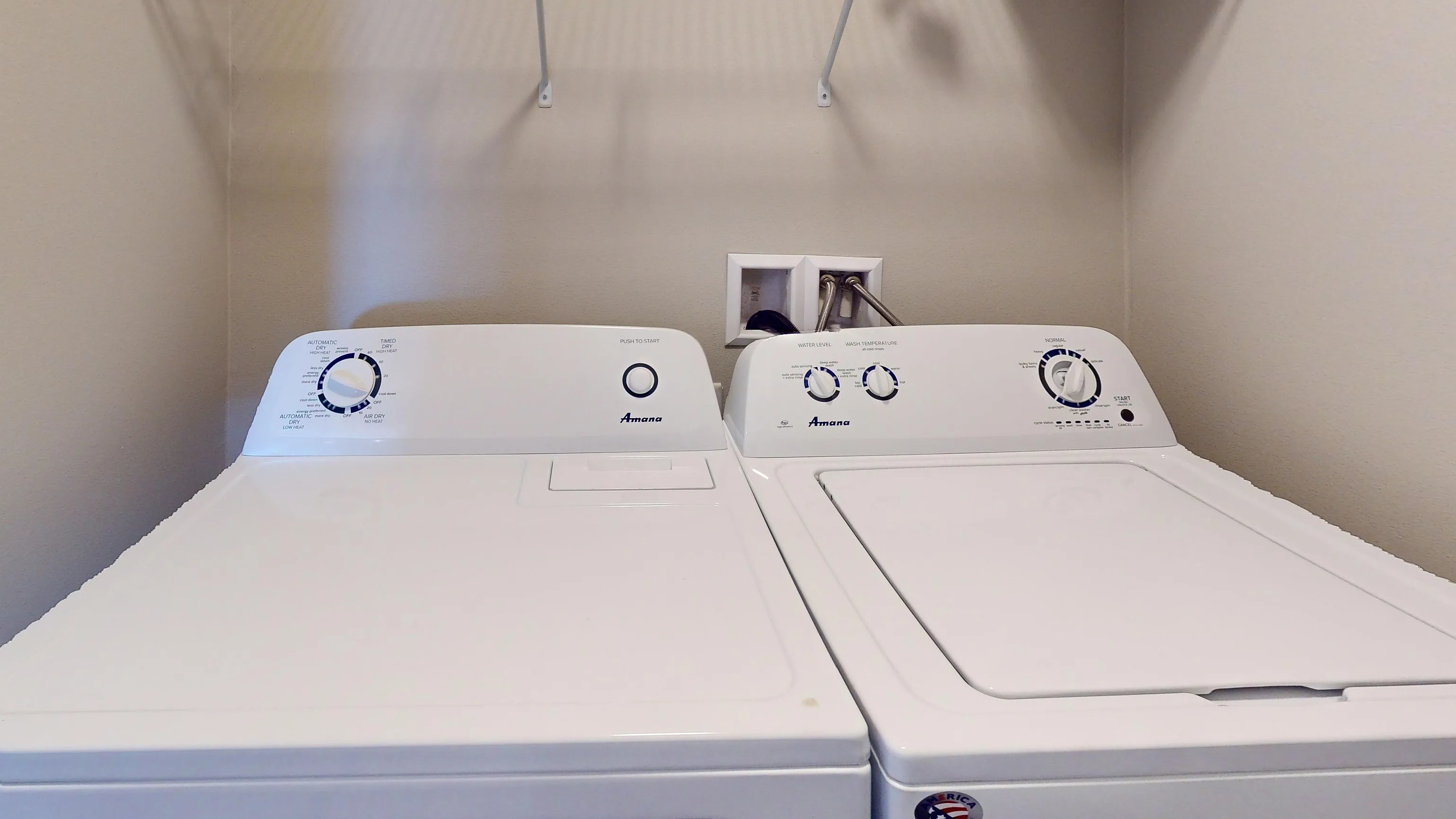 Modern laundry room featuring a sleek washer and dryer set with convenient shelving for storage.
