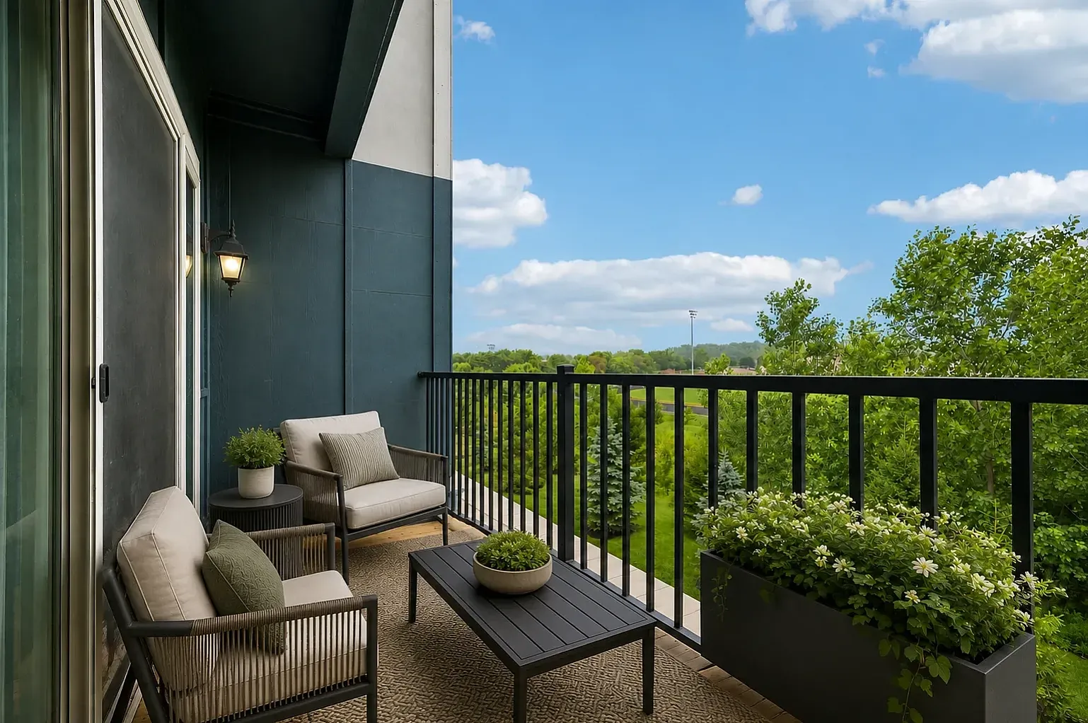 Apartment balcony overlooking landscaped green space with trees.