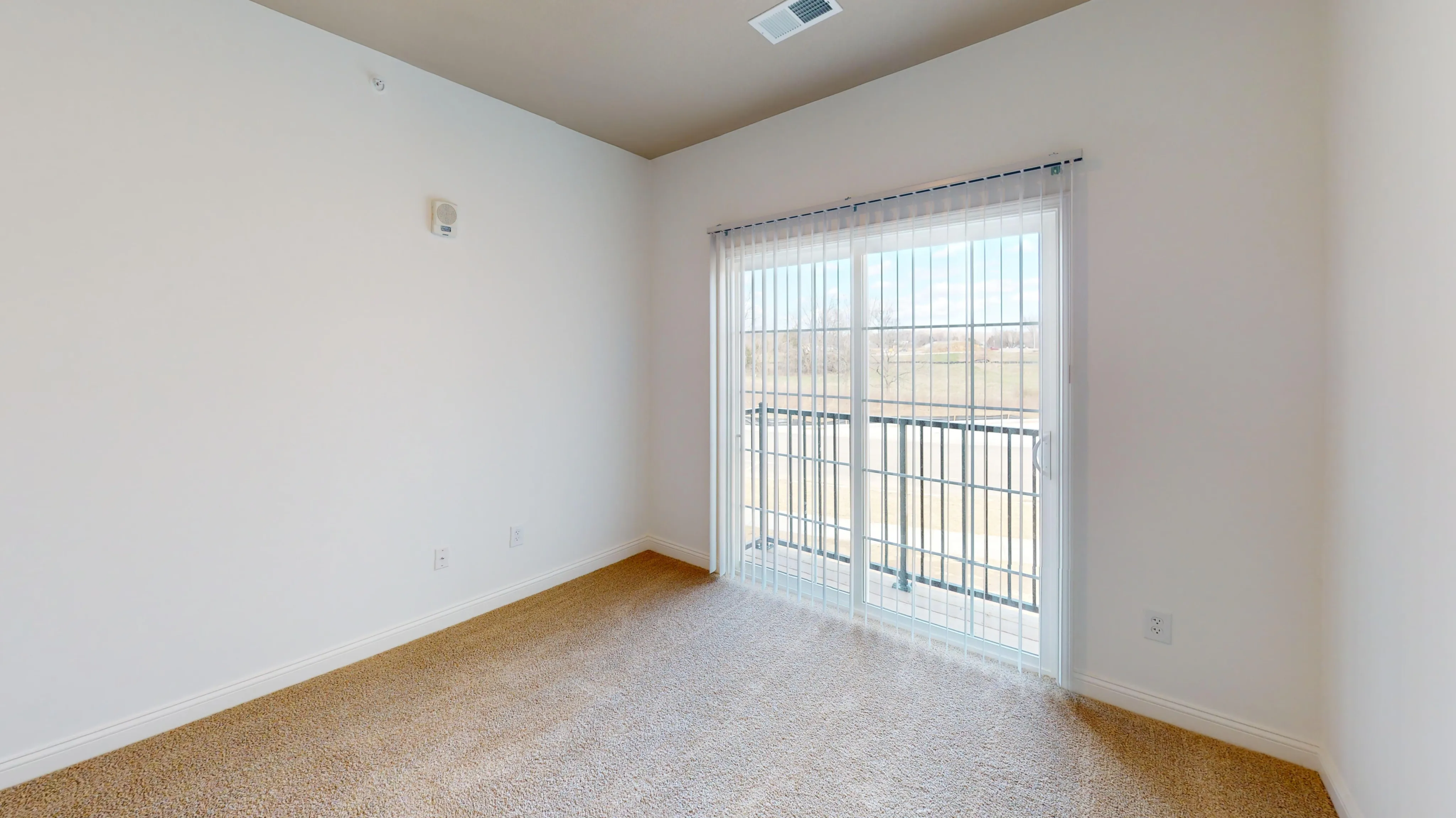 Bright and airy bedroom with sliding glass door that goes to private balcony.