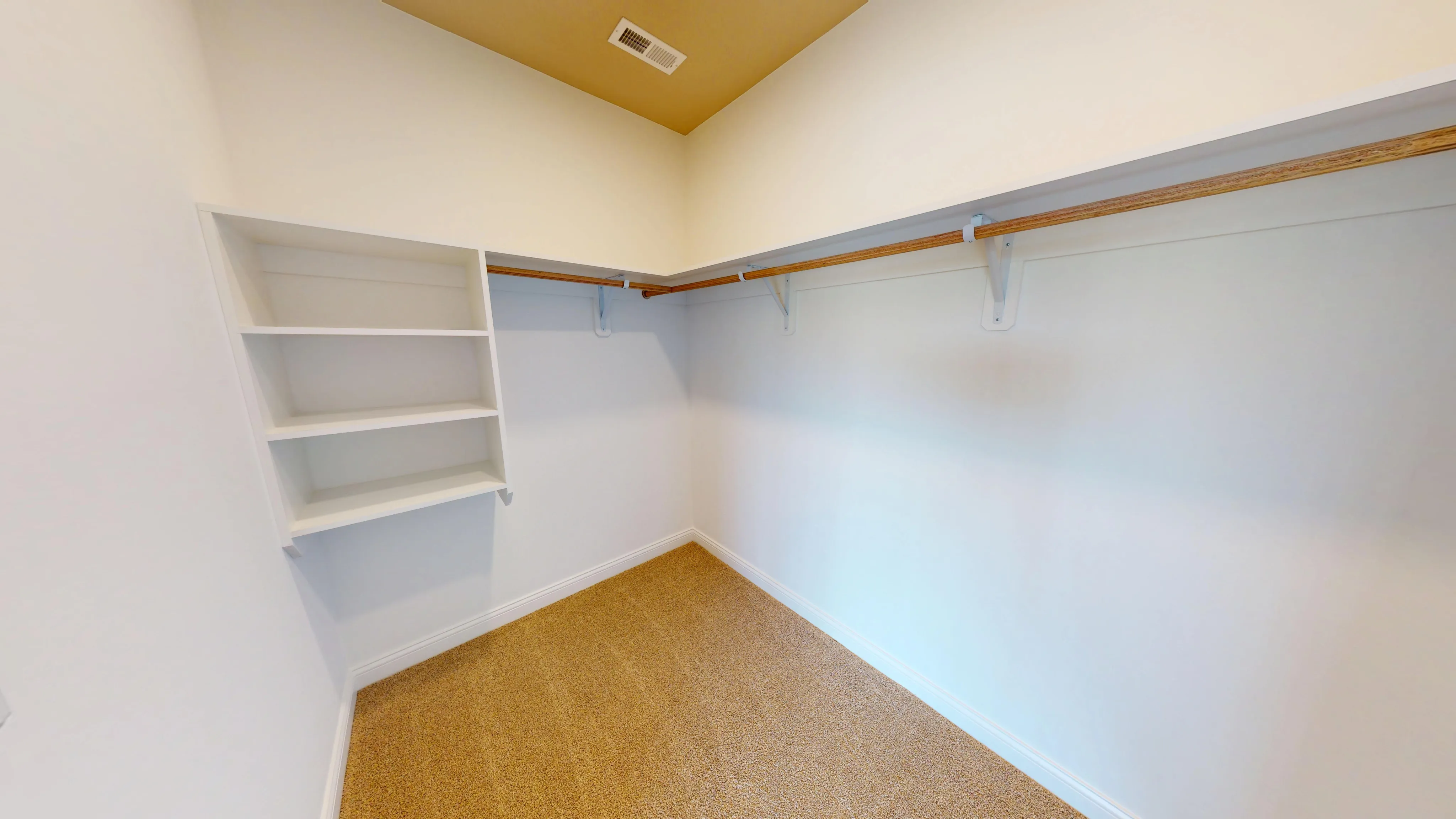 Bright walk-in closet featuring custom-built shelves.