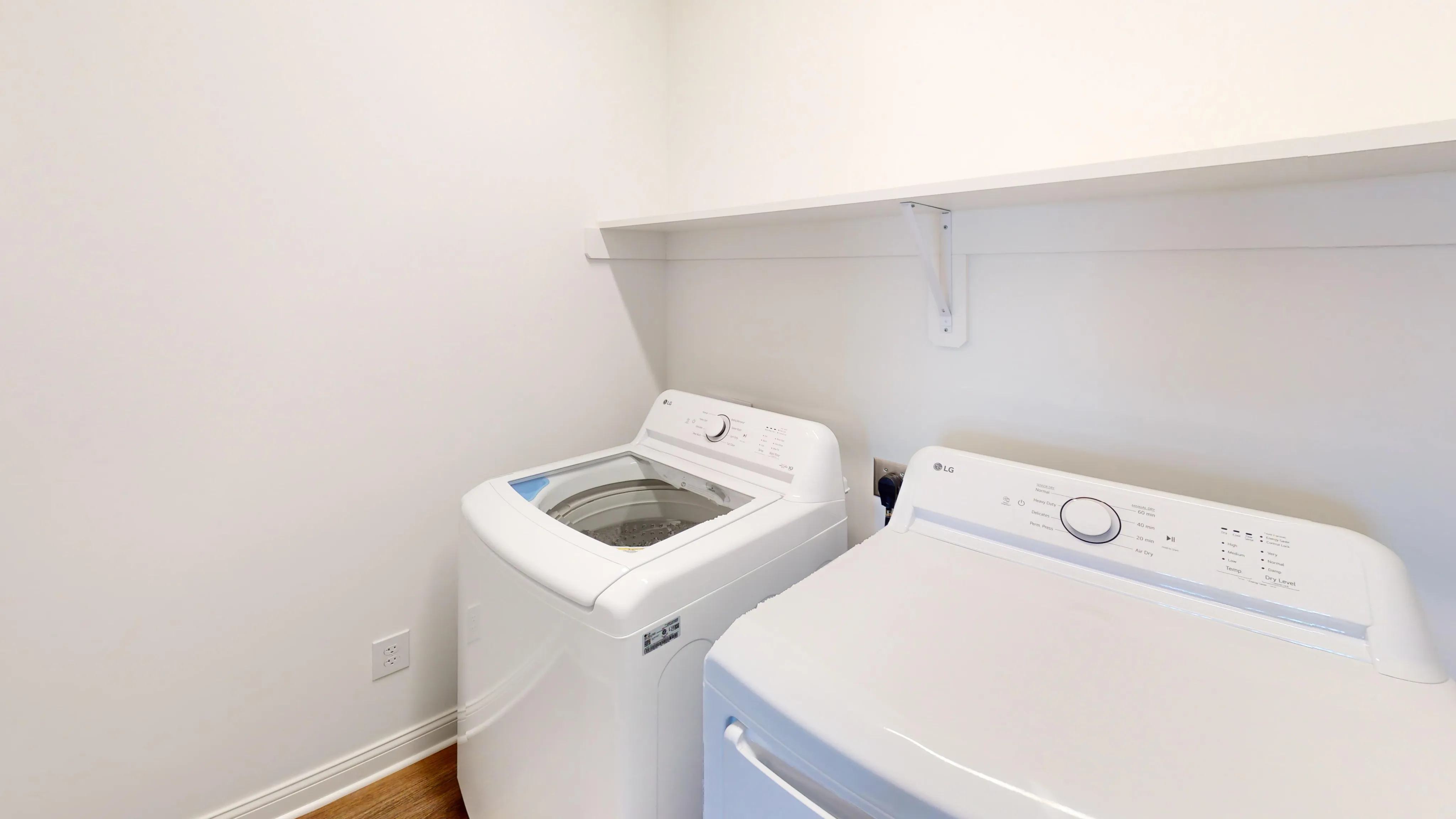 Bright laundry room with a white full-size wahser and dryer set.