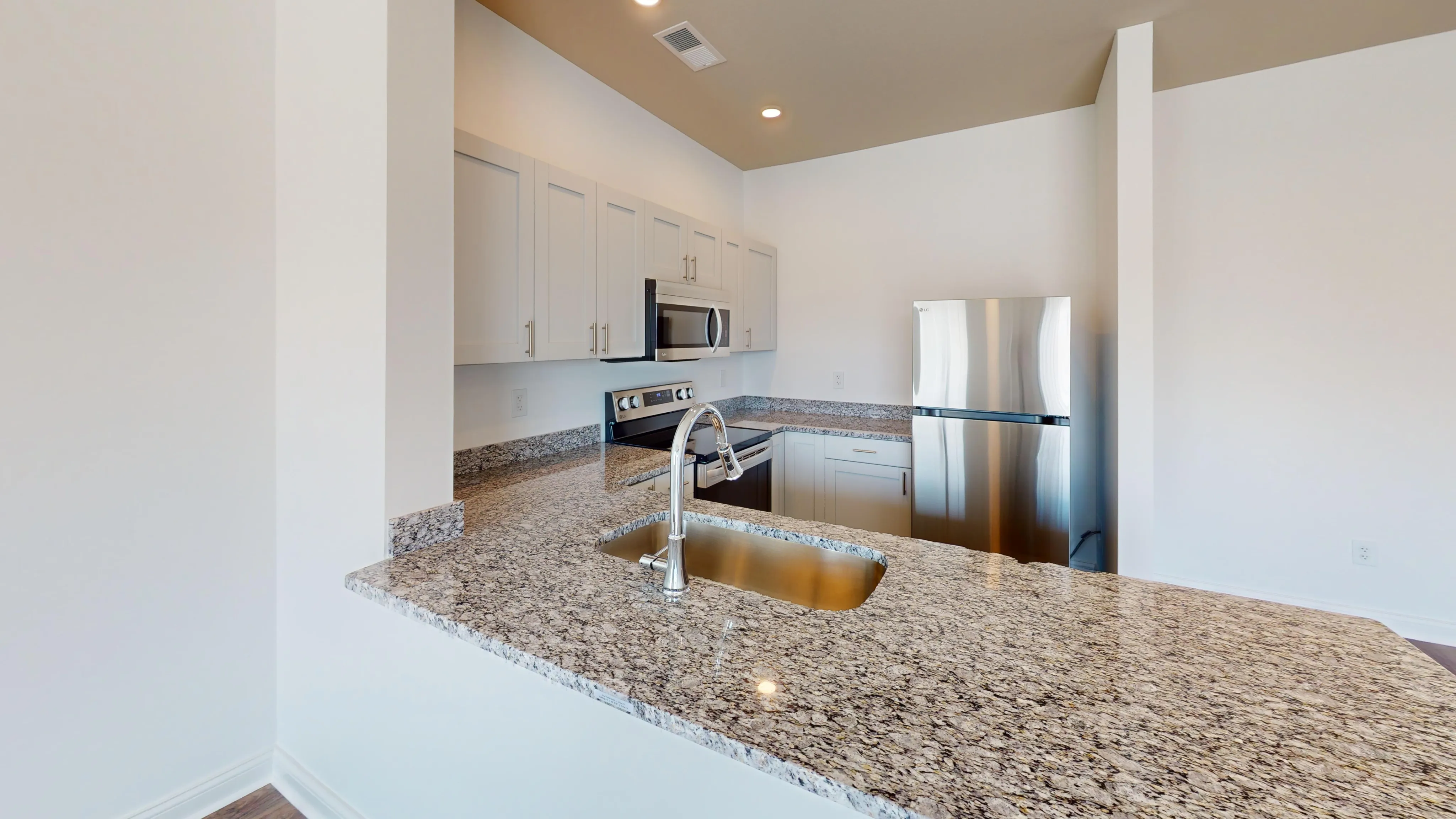 Modern kitchen with sleek granite countertops, stainless steel appliances, and ample cabinet space.