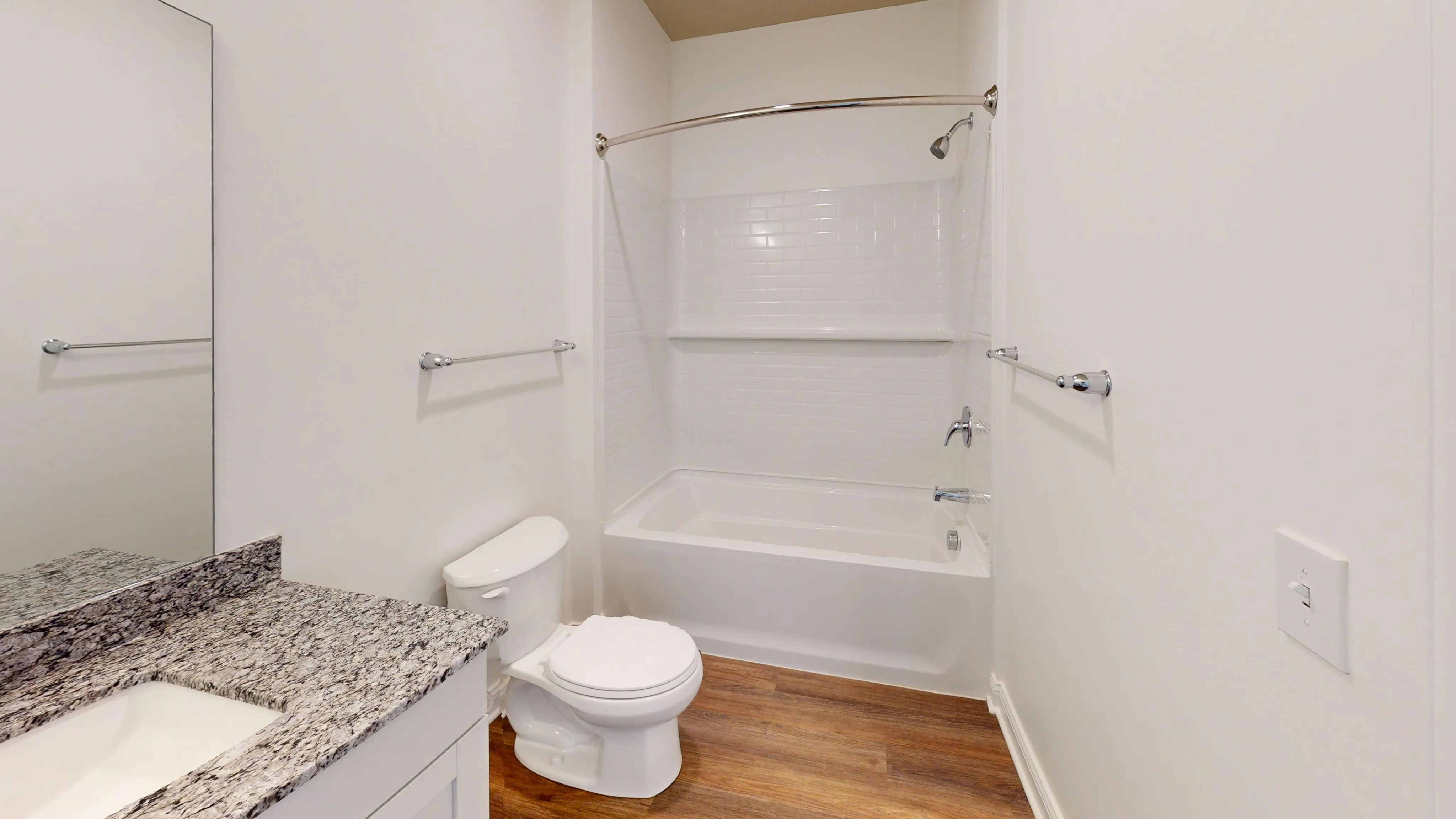 Elegant bathroom featuring a polished granite countertop, modern fixtures, and a chic shower-tub combination.