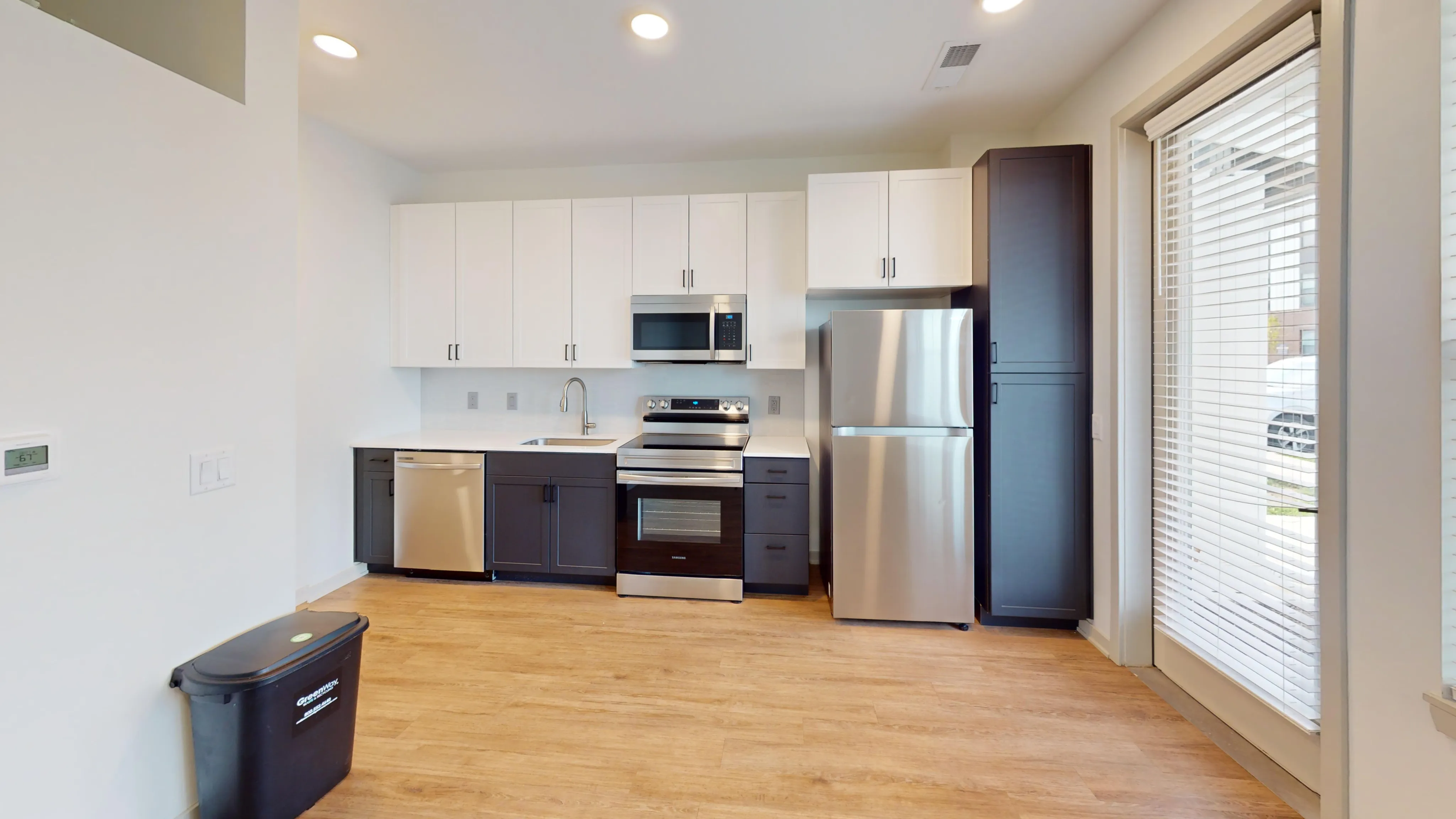 Modern kitchen with sleek stainless steel appliances, elegant cabinetry, and large windows for natural light.