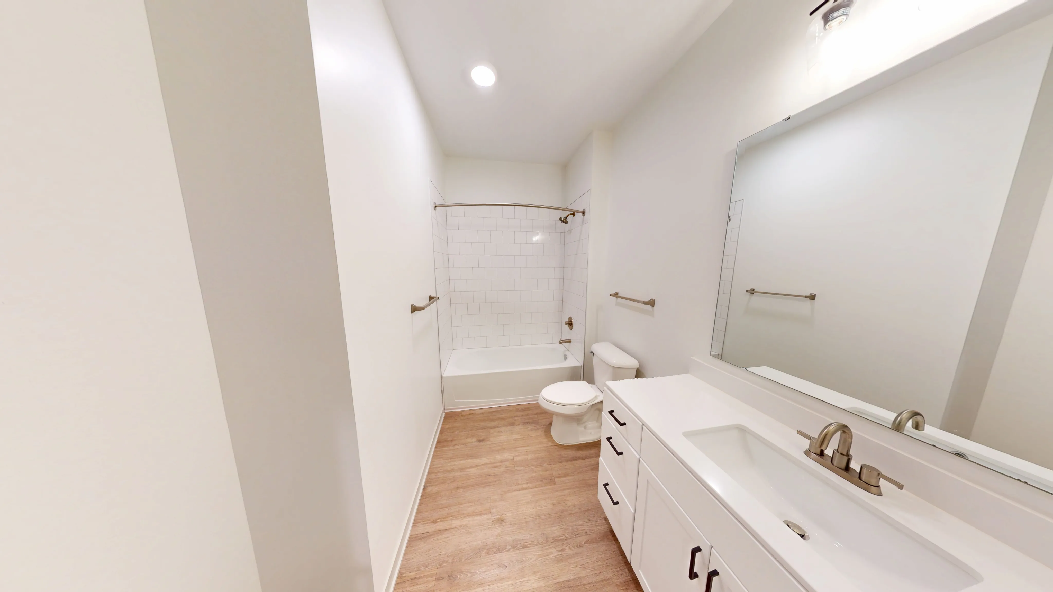 Modern bathroom design showcasing sleek white cabinetry, contemporary fixtures, and elegantly tiled shower in a spacious floor plan.