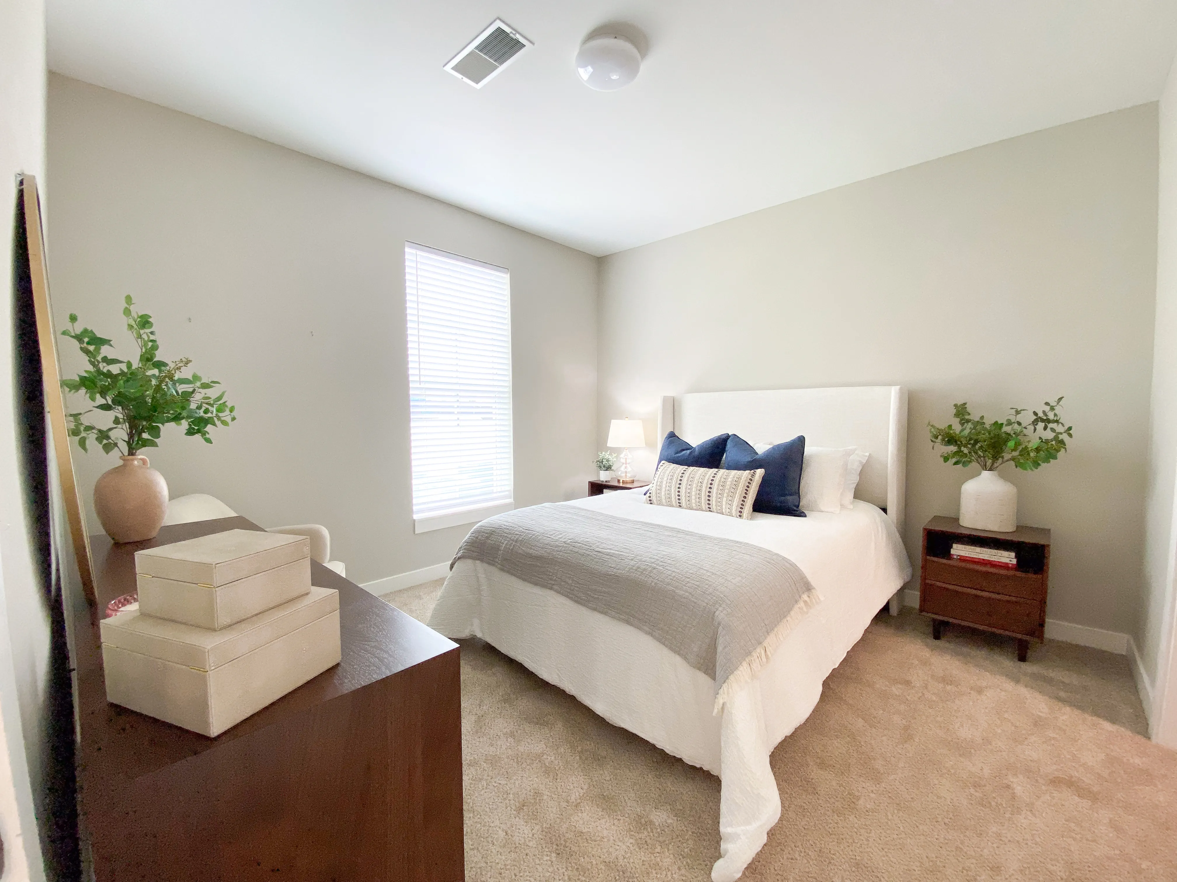 Elegant bedroom with a plush bed, stylish decor, and abundant natural light creating a cozy ambiance.
