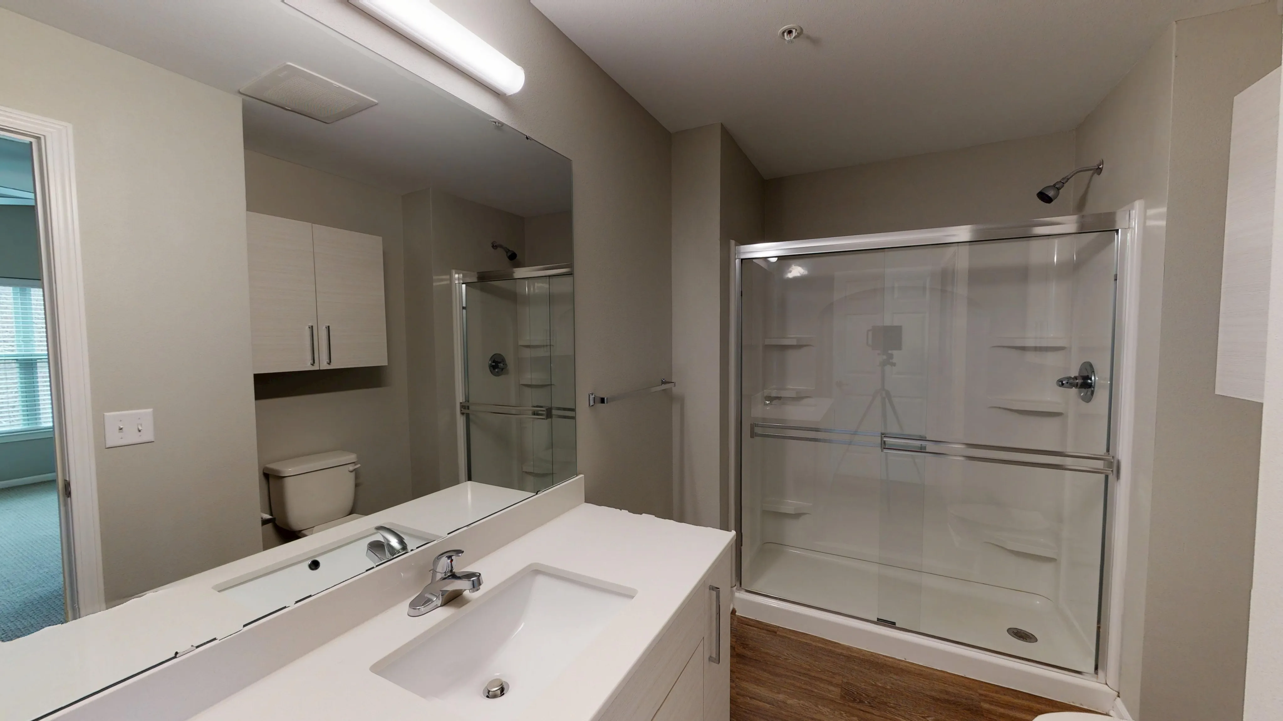 Modern bathroom with sleek glass shower, stylish vanity, and elegant lighting. Natural tones create a sense of relaxation.