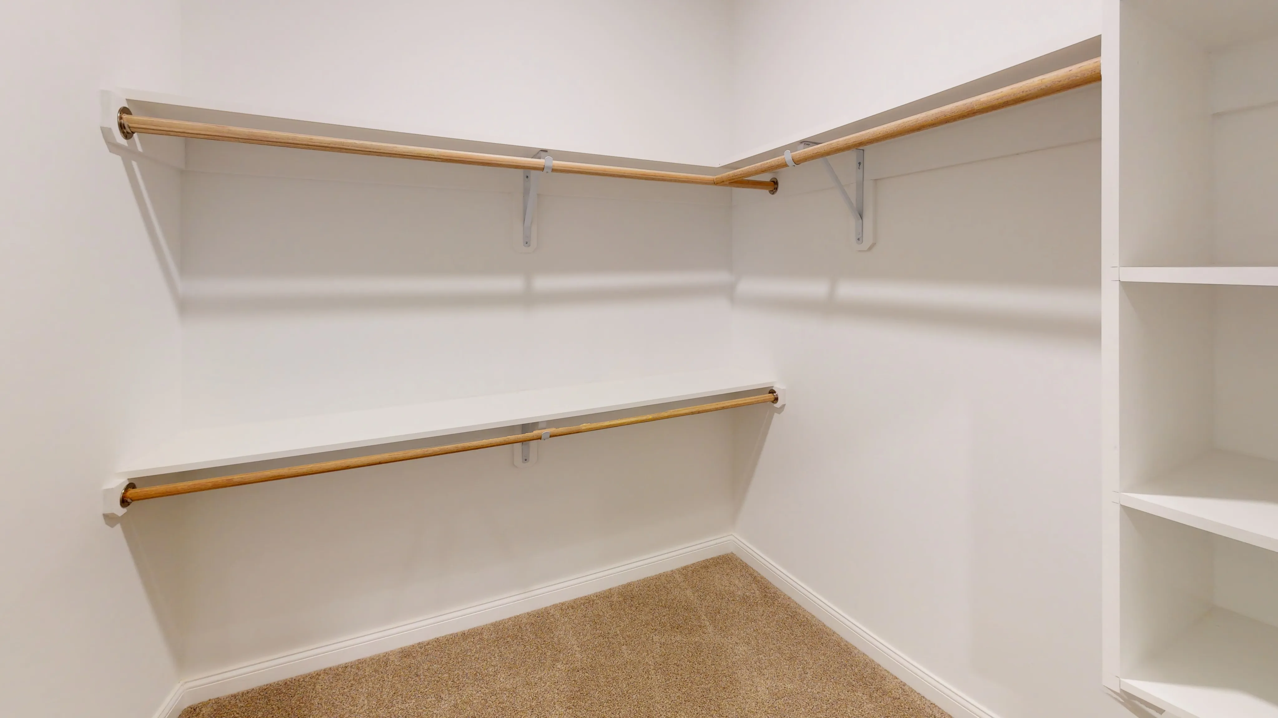 Spacious walk-in closet with built-in shelves and ample hanging space, perfect for organizing a modern wardrobe.