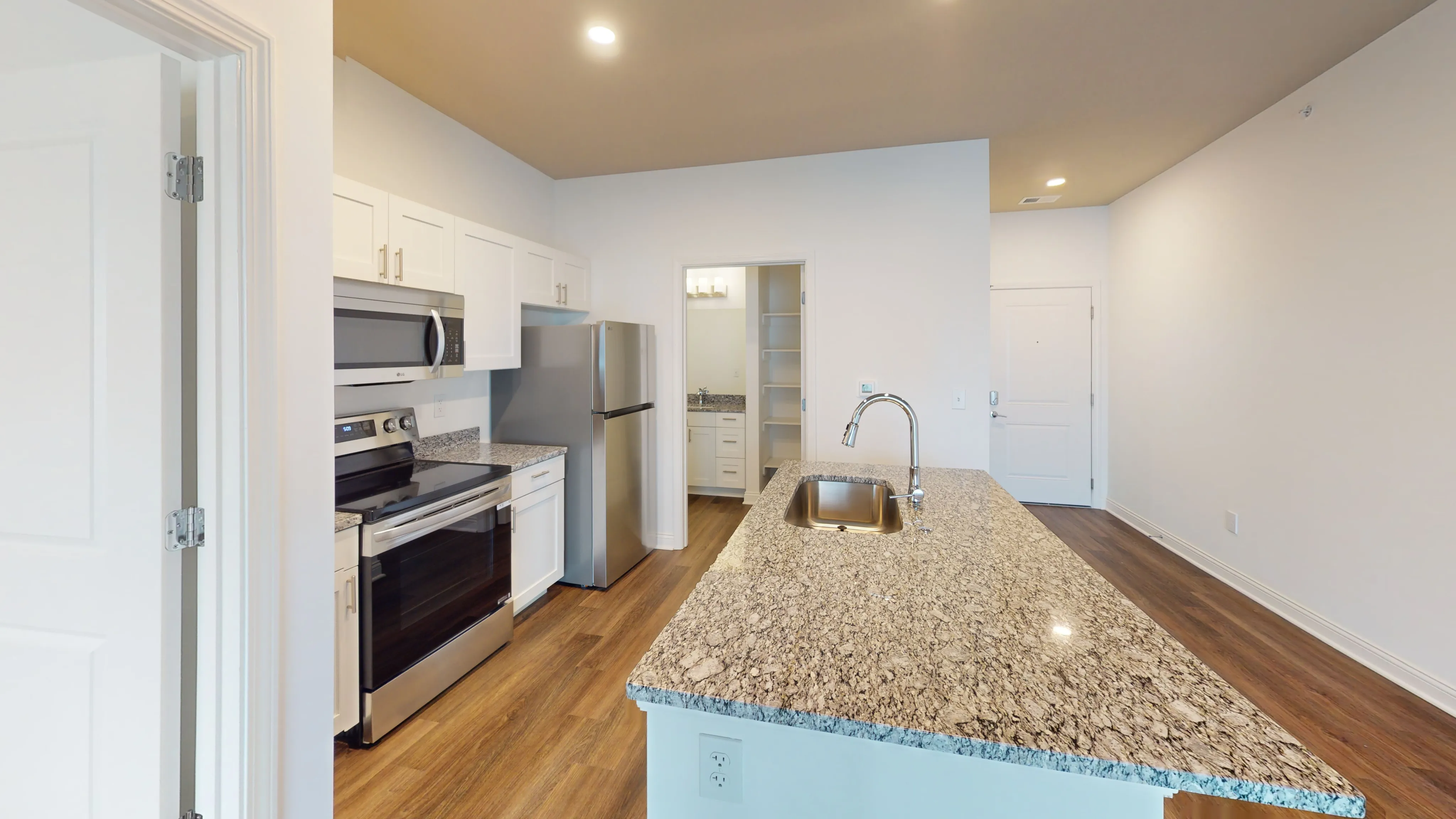 Modern kitchen with sleek stainless steel appliances, elegant granite countertops, and a stylish open layout.