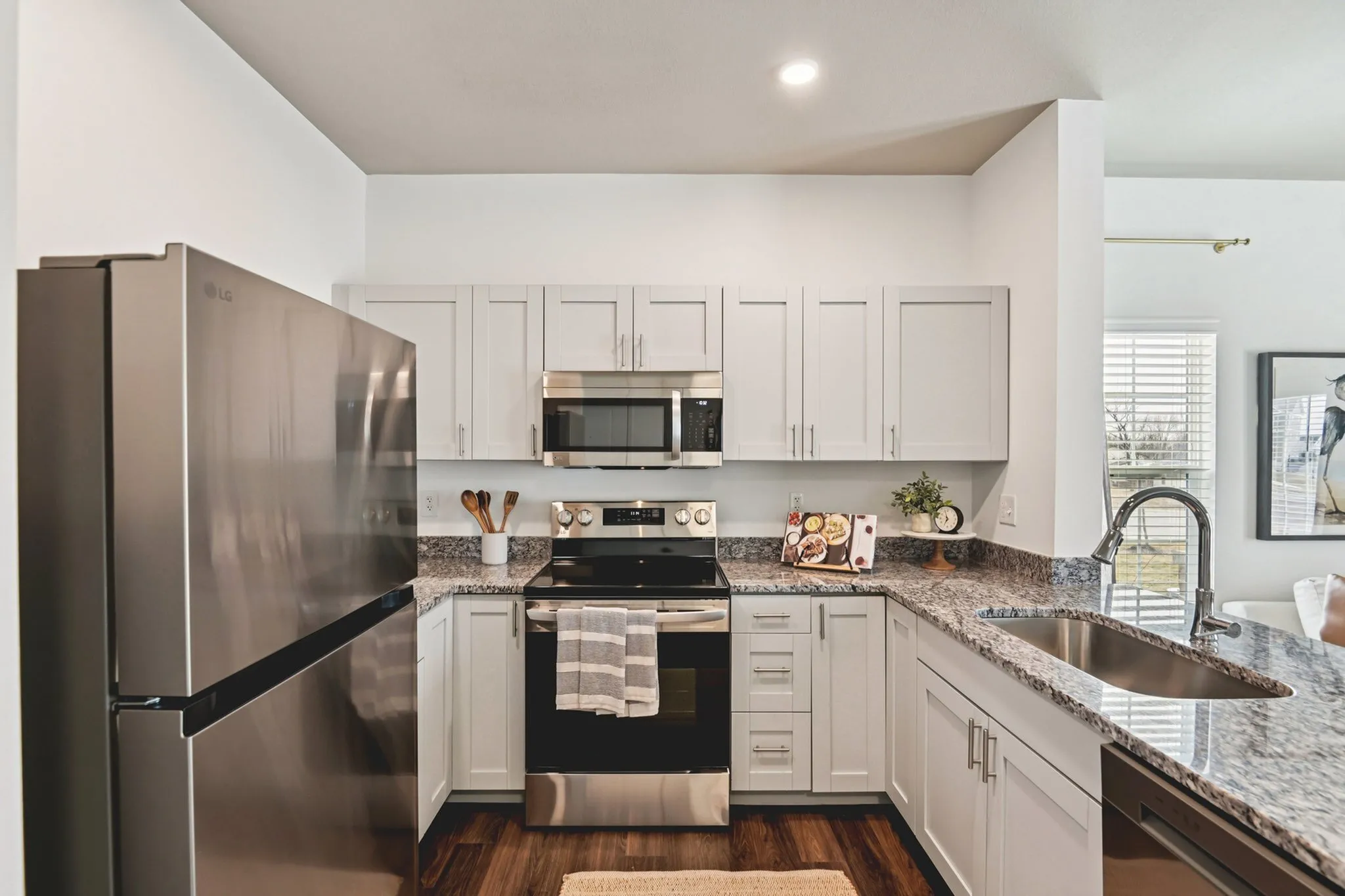 Modern kitchen with sleek stainless steel appliances, elegant granite countertops, and ample white cabinetry, offering a bright and inviting space for culinary creativity.