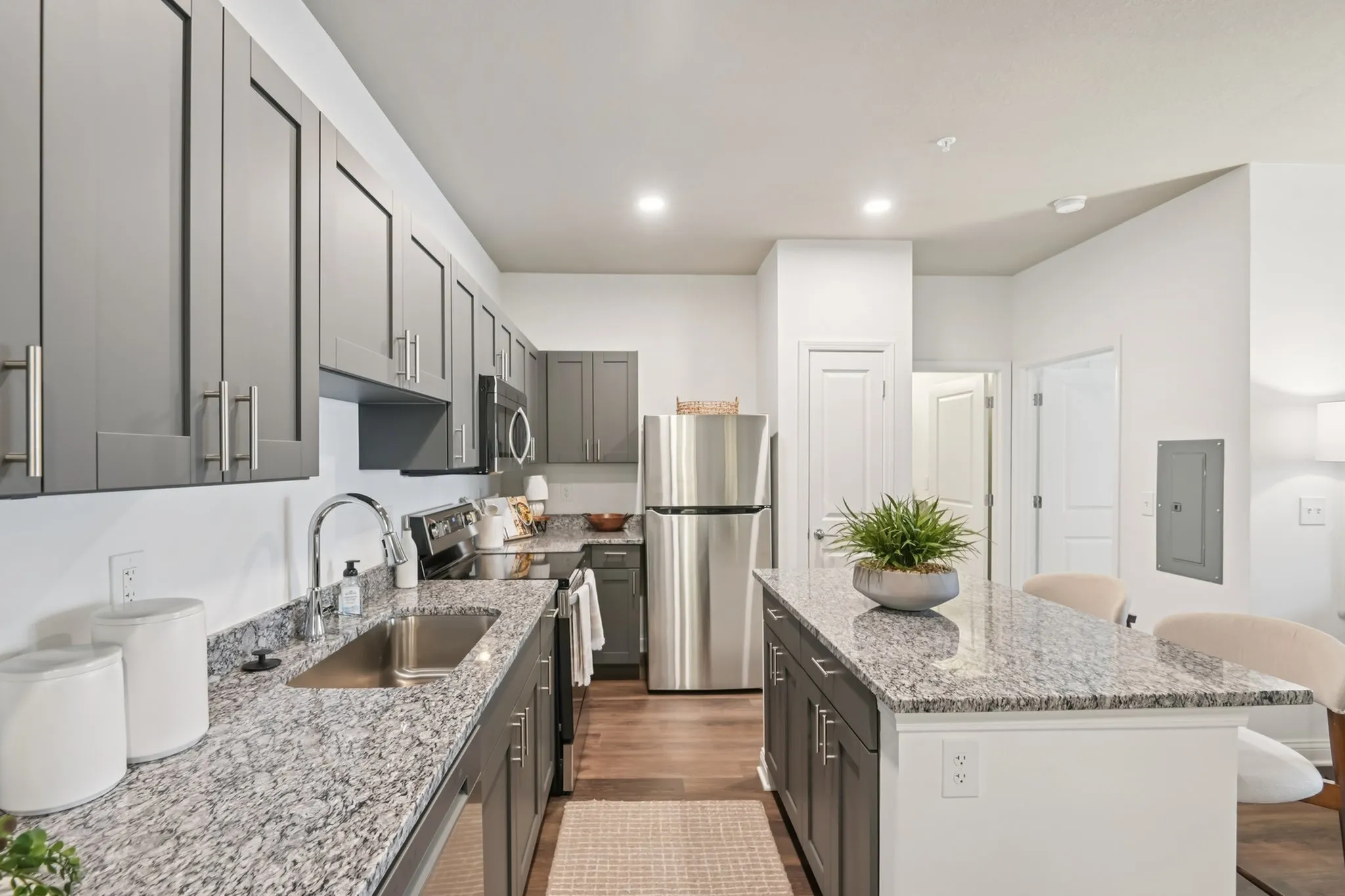 Modern kitchen with sleek gray cabinetry, stainless steel appliances, and a granite island countertop offering stylish convenience.