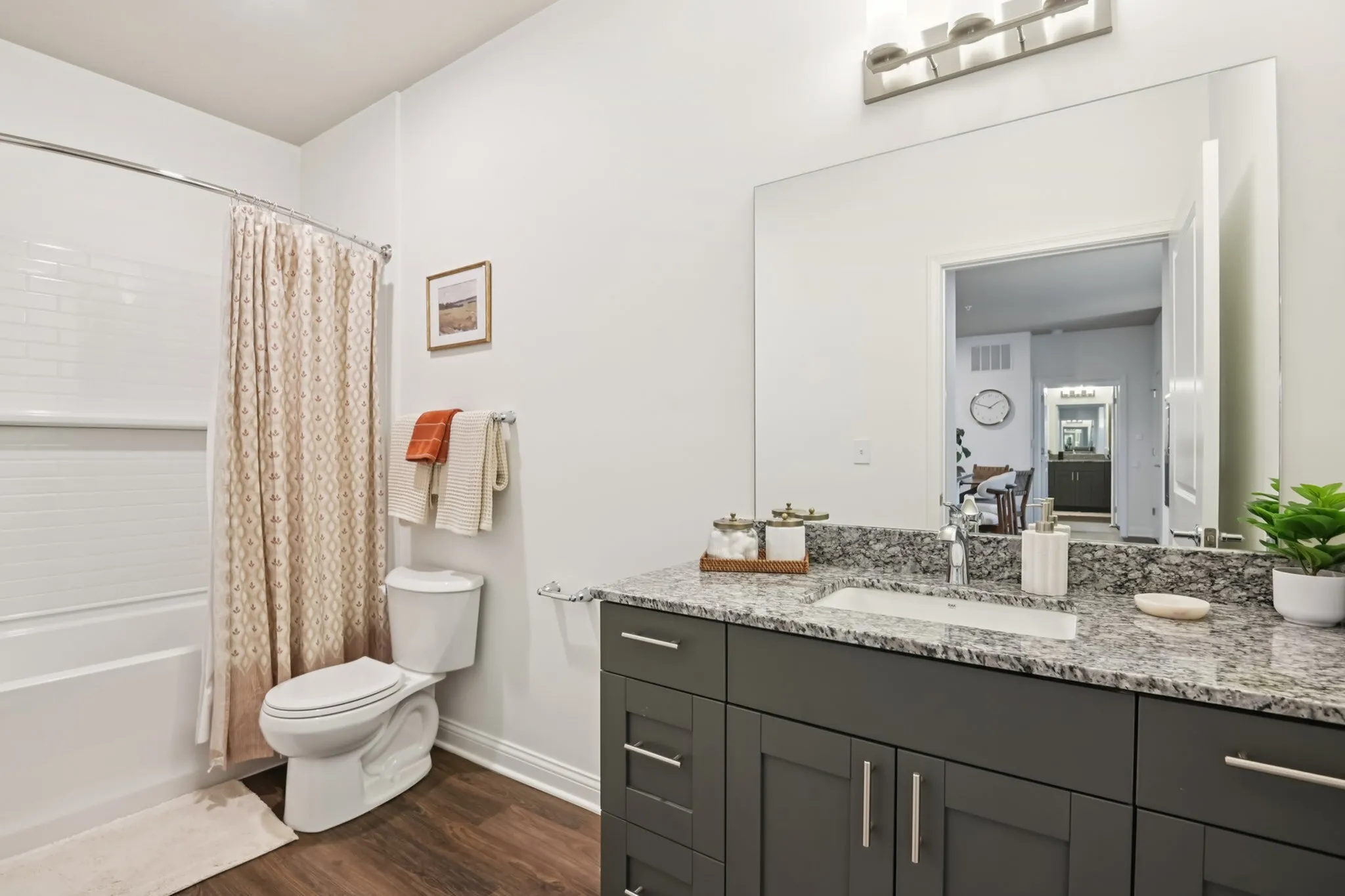Modern bathroom with elegant granite countertop, stylish vanity, soft lighting, and inviting shower area.