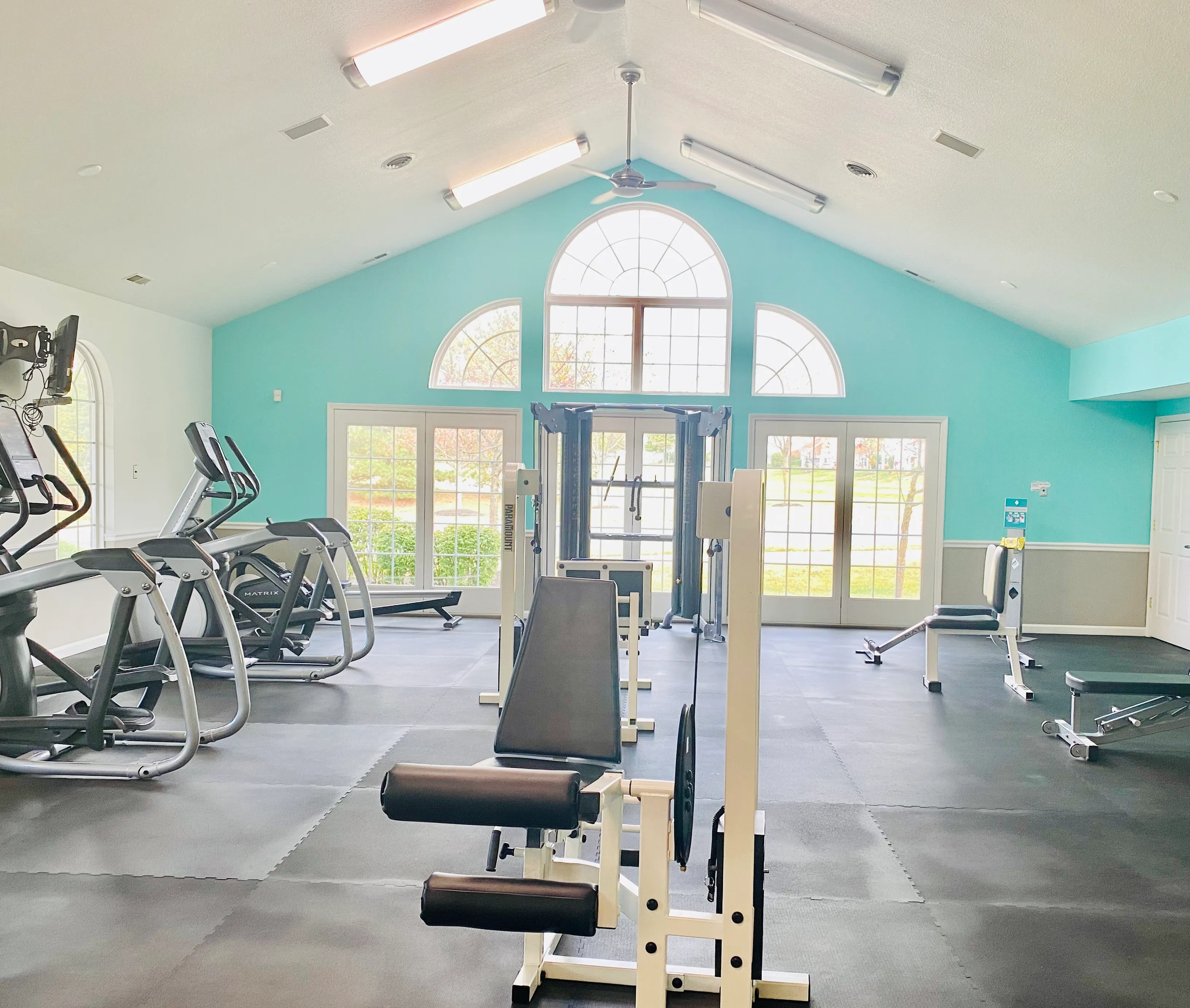 Bright and airy fitness center with modern exercise equipment and large windows.