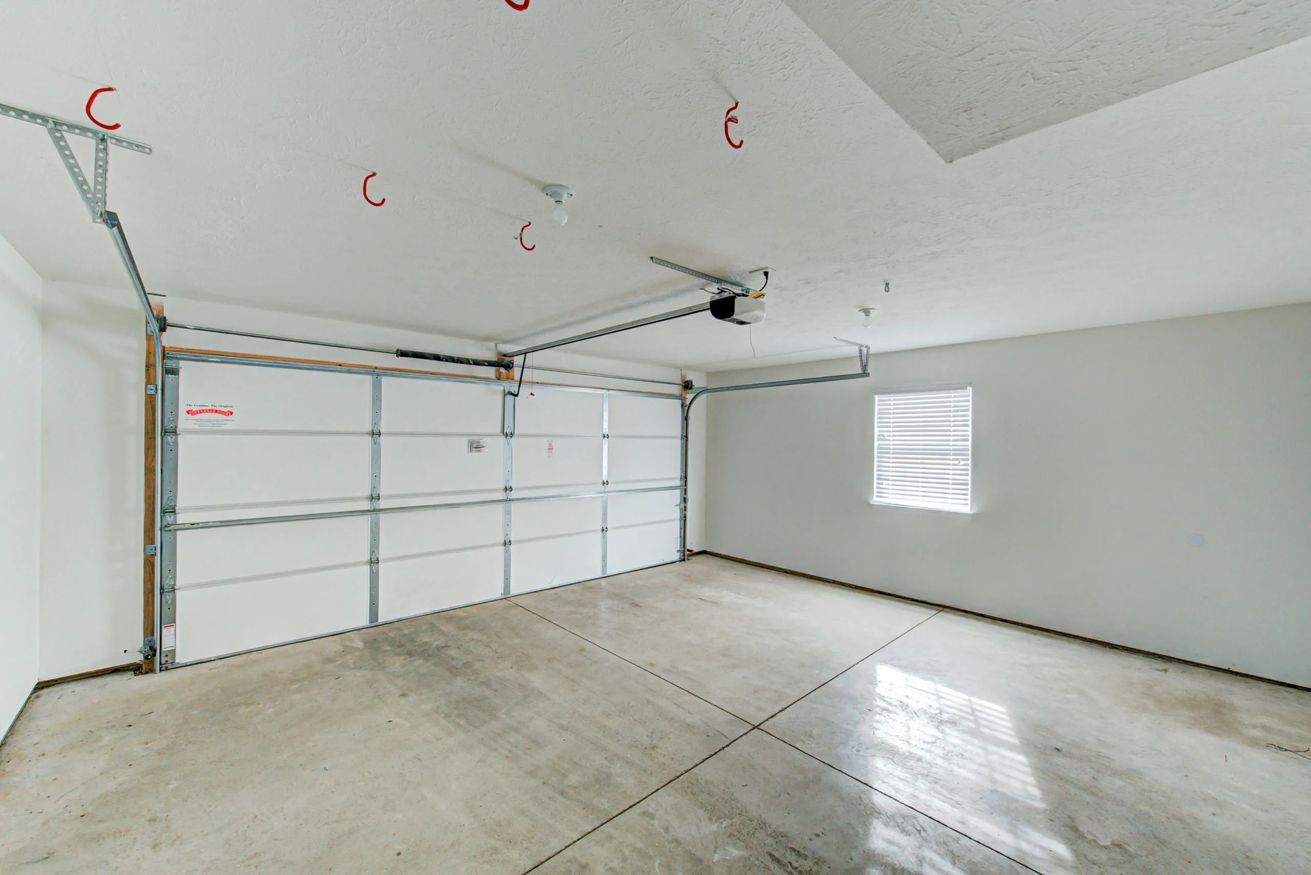 Spacious and pristine two-car garage with modern automatic door and natural light.