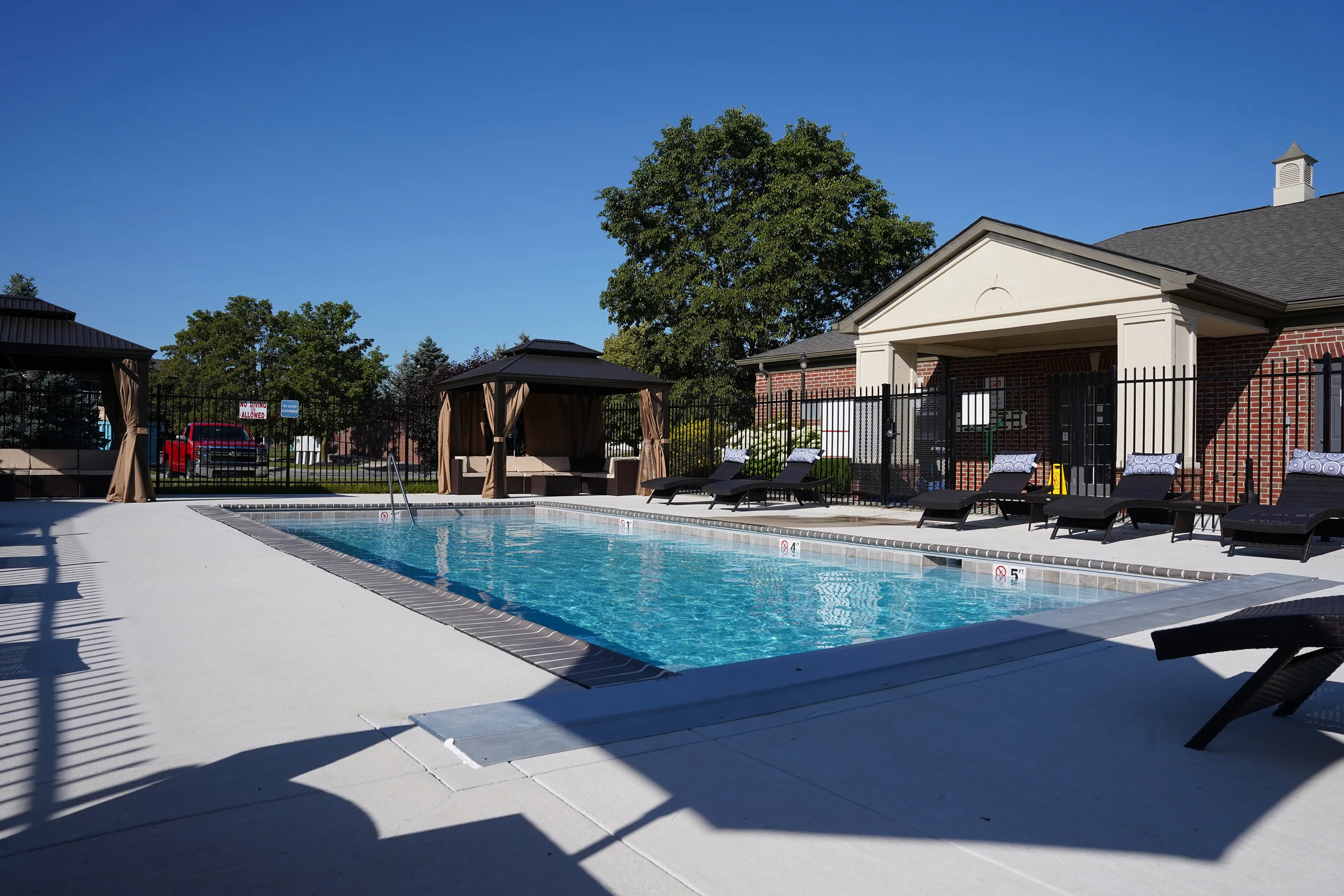 Inviting outdoor pool area with chic cabanas and comfortable lounge chairs, perfect for relaxation in a serene setting.