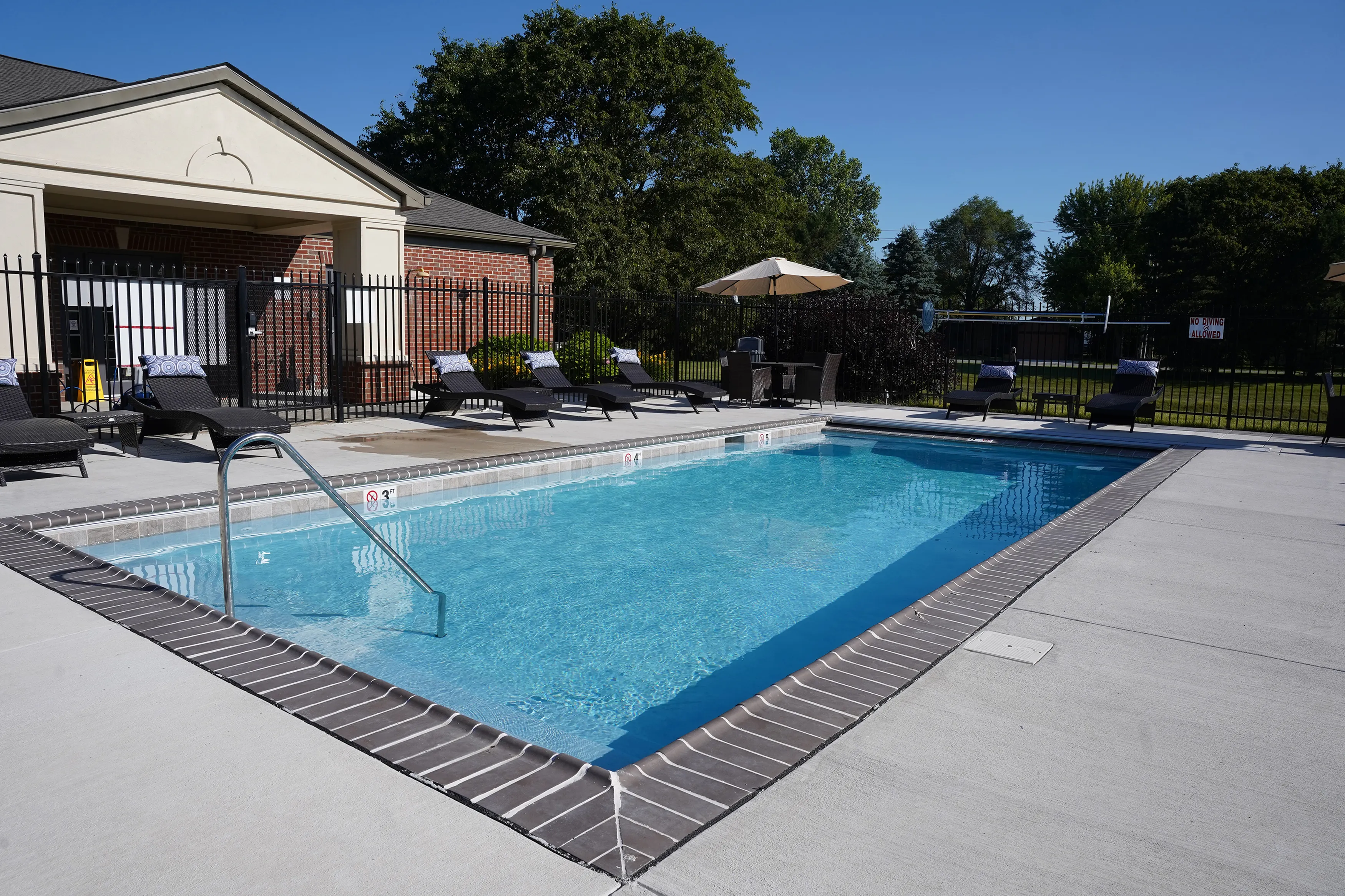 Inviting outdoor pool area with comfortable lounge chairs and umbrellas, perfect for relaxation and leisure.