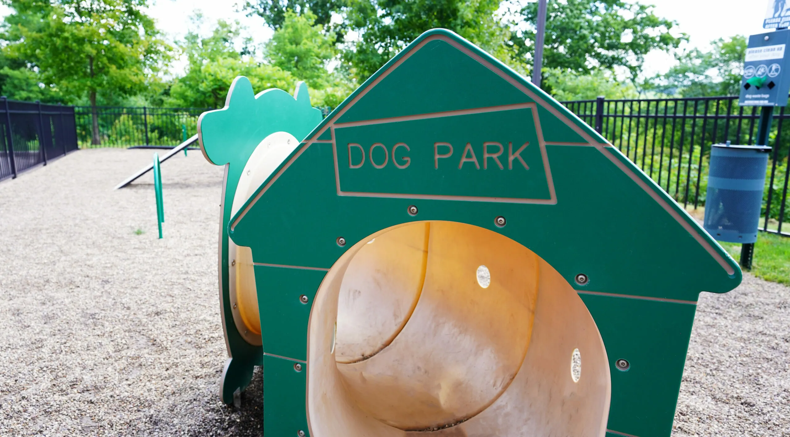 Inviting dog park with vibrant green structures and open play area, perfect for pets to enjoy and interact.