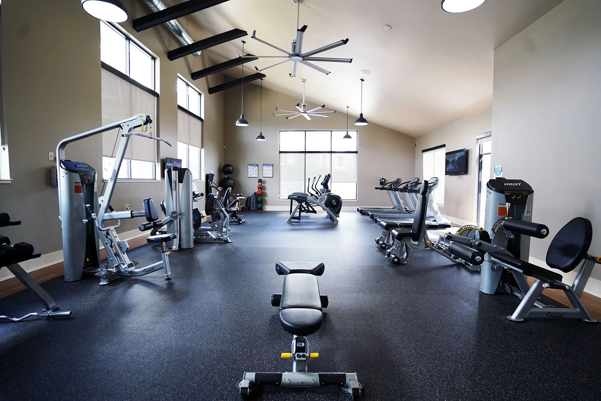 Modern fitness center with state-of-the-art equipment, high ceilings, and ample natural light for an inspiring workout.
