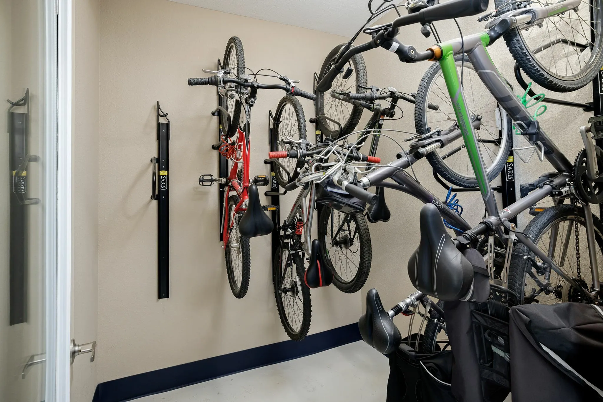 Modern apartment bike storage room with multiple bikes mounted on sturdy wall racks, maximizing space and providing organized convenience.