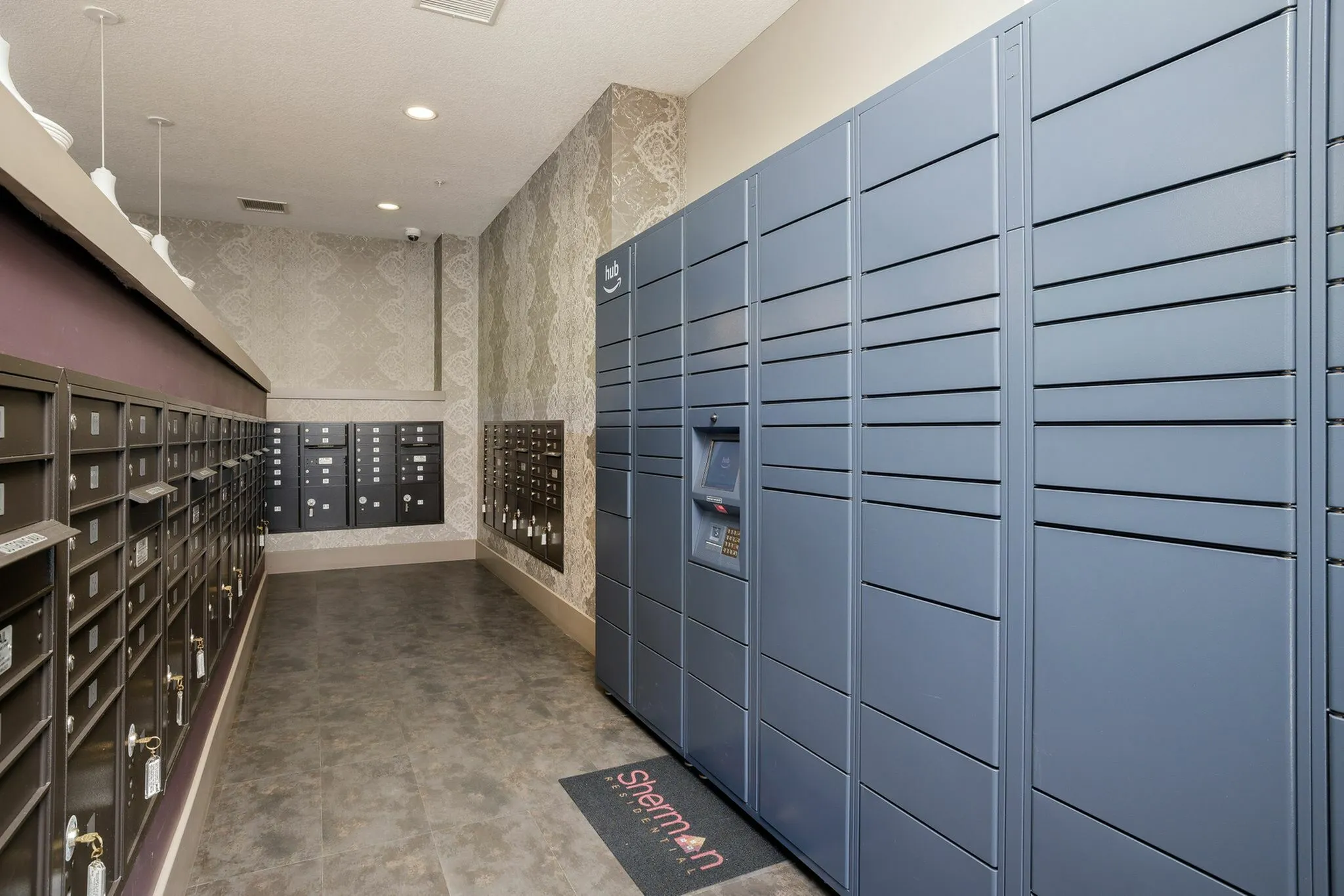 Modern apartment mailroom featuring sleek blue parcel lockers and a wall of individual mailboxes, offering secure and convenient package management.