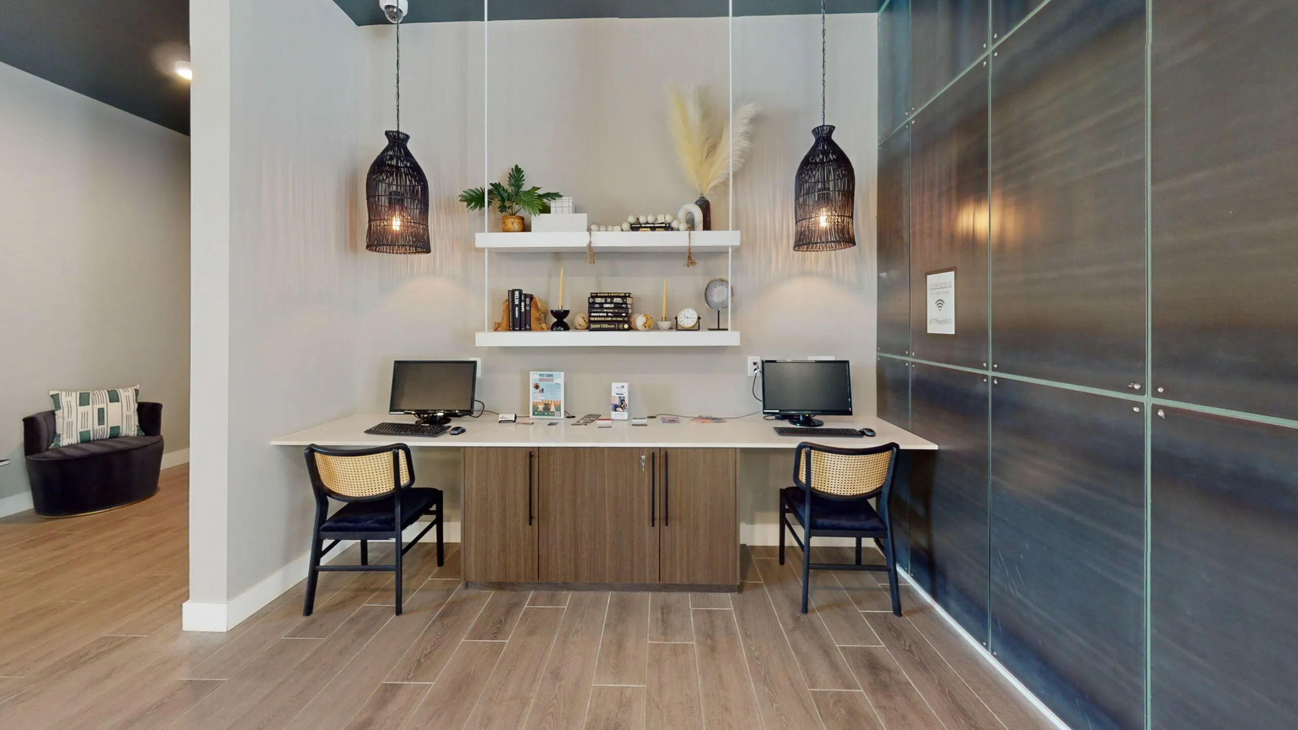 Chic modern workspace with dual computer stations, elegant wood cabinetry, and stylish decor accents in a sleek apartment setting.