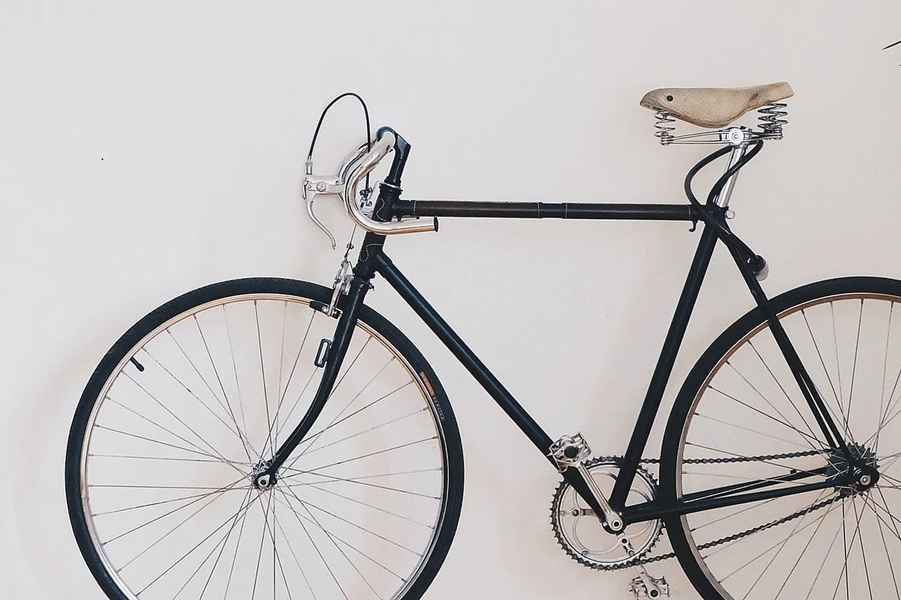 Elegant modern apartment with minimalist decor featuring a sleek bicycle against a pristine white wall, showcasing contemporary style.