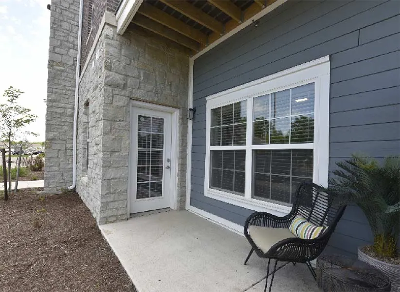 Charming apartment patio with elegant stone walls, cozy seating, and inviting atmosphere.