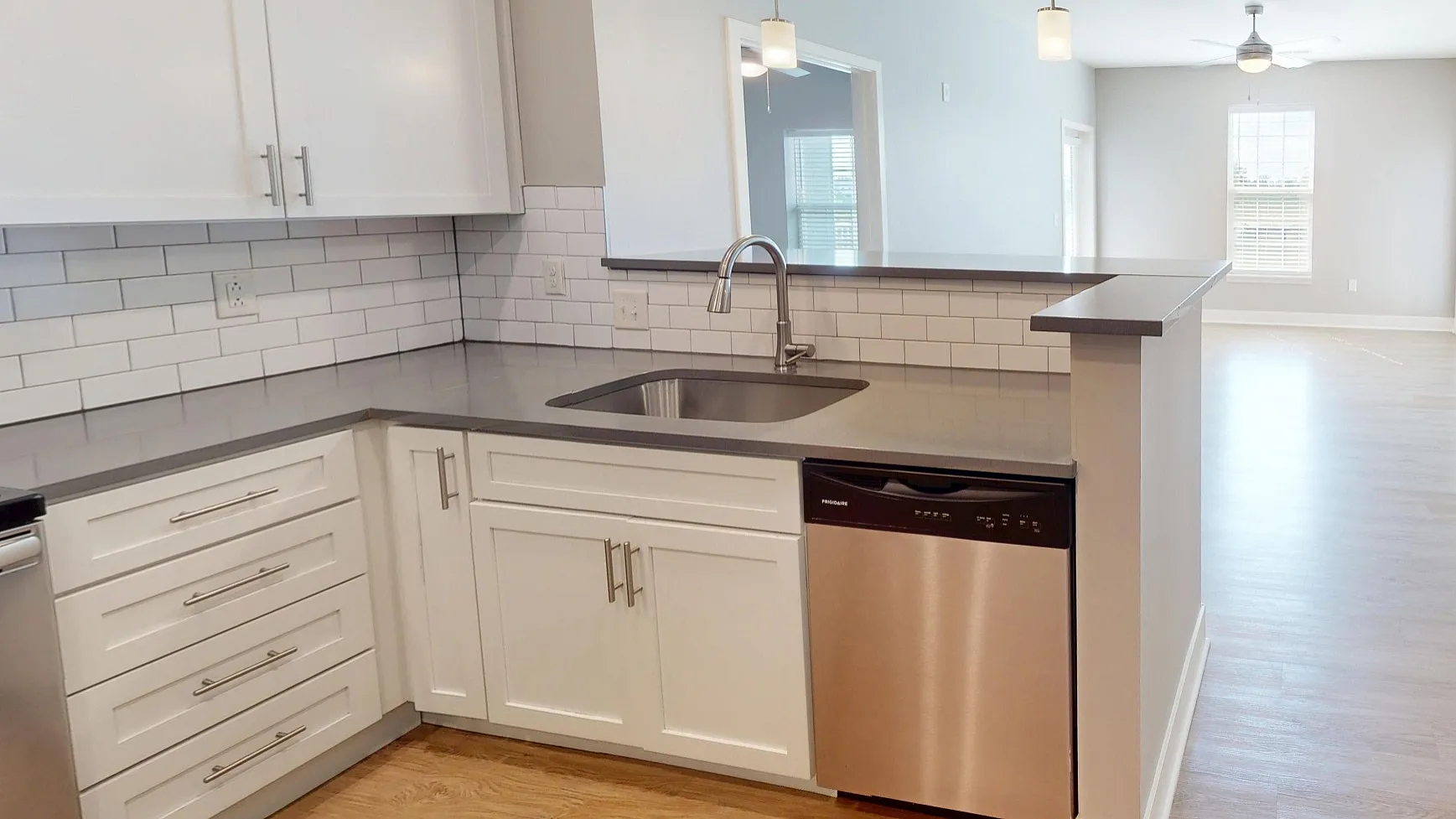 Modern open-plan apartment featuring a sleek kitchen with stainless steel appliances and ample natural light flowing into the spacious living area.