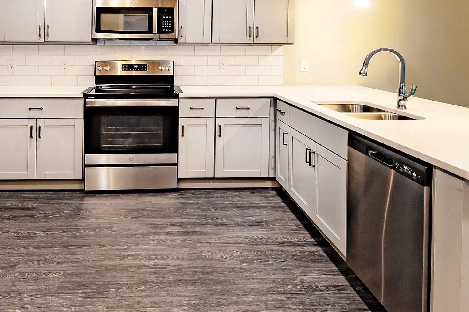 Modern kitchen with sleek stainless steel appliances, elegant gray cabinetry, and spacious island countertop.