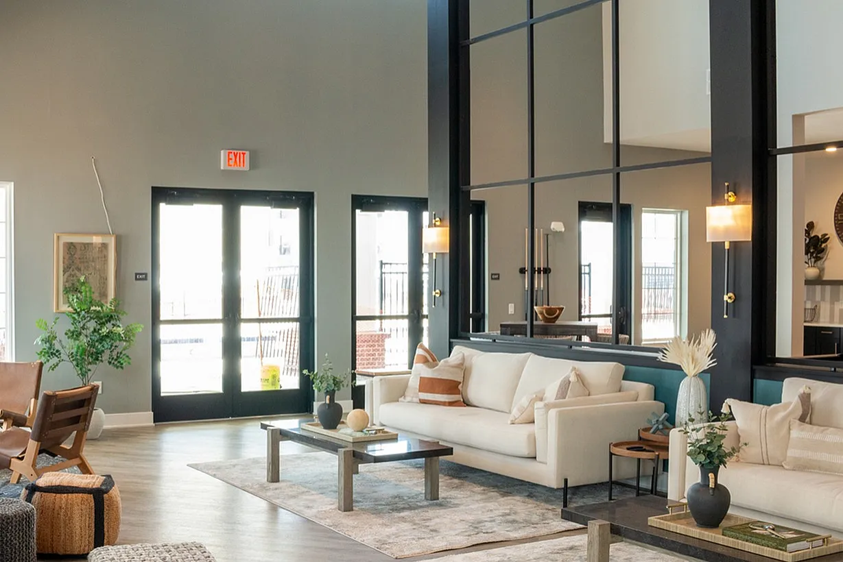 Elegant open-plan living area featuring modern furniture, stylish decor, and abundant natural light through large windows.